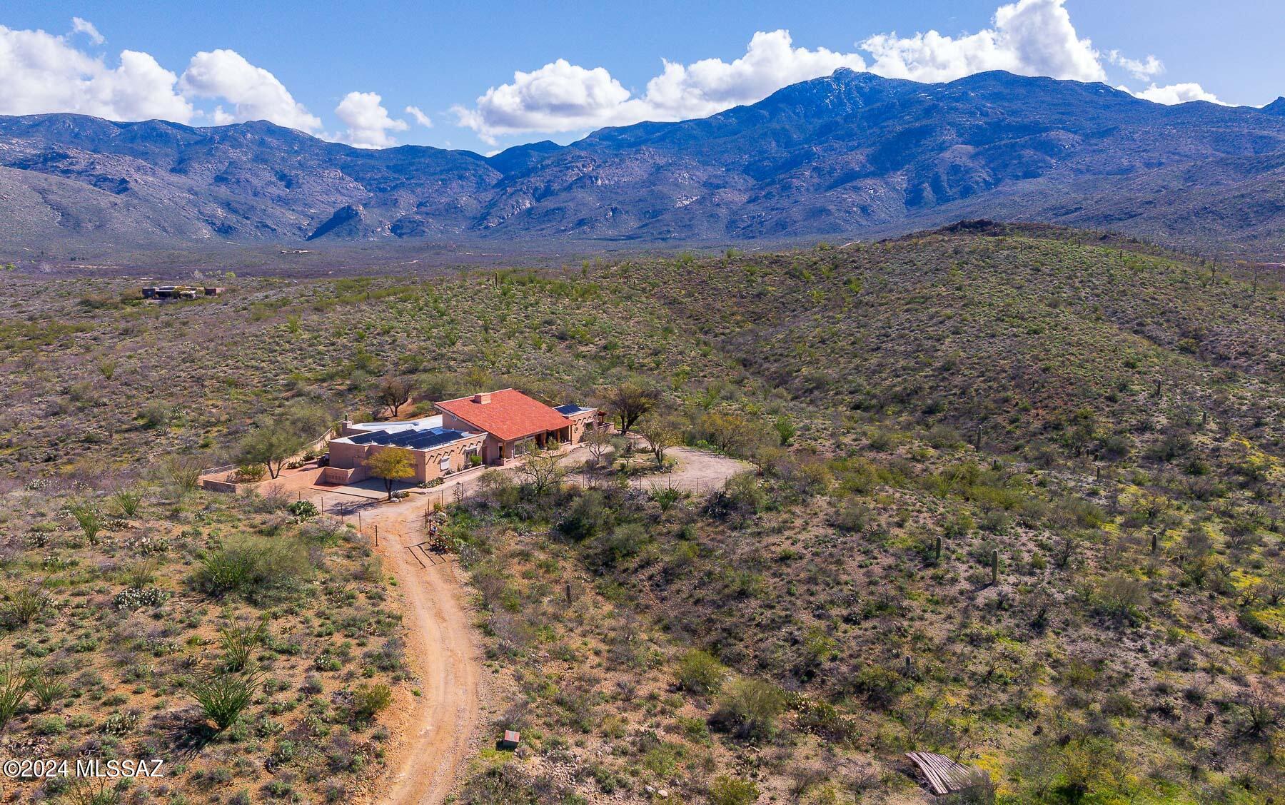 This home is absolutely Arizona! Welcome home to your own 36 acres of pristine natural desert that surrounds a beautiful 4381 sq ft, 5 bedroom, 3 bath, 2 car garage ranch house.  Entry is graced by double wood doors & rock fireplace that can be seen from every living area of the home.  Wood beams are from local Mount Lemmon. Stain glass window accents throughout. 985 bottle walk in wine cellar with glass walls. Gourmet kitchen w/ granite, stainless steel appliances, & beehive fireplace in breakfast nook area.  Guest rooms have their own unique features including sauna, private entry door, private patio and secret loft! Master suite has large bedroom, walk in closet, atrium sun room, & master bathroom w/ walk-in shower & jacuzzi tub. Walled back yard with spa & endless mountain views! Home includes well, owned solar, & two driveway gates. Gated community made up of 57 lots w/min lot split of 36 acres. 35 minutes from downtown Tucson. Located in Vail School District, and 15 minutes from shopping, doctors offices & more.  This is the home buyers dream of!  Come see it while it lasts!