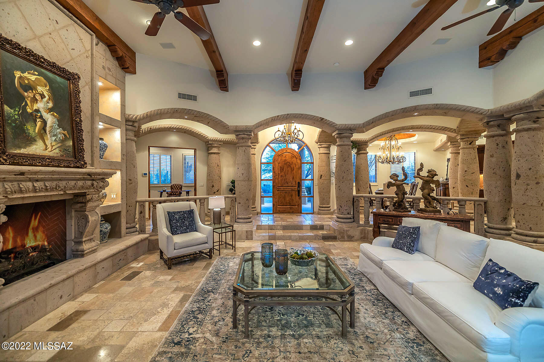 Located in the prestigious gated community of Pima Canyon Estates on a premier 1-acre lot, this custom 4bed/5bath Mediterranean home encompasses privacy & luxury throughout. Open concept design boasts beamed ceilings, seamless transitions throughout sun-filled living areas, custom alder wood cabinetry, & oversized windows that showcase stunning mountain & sunset views. Entertain guests in chef's kitchen w/ SS appliances, wet bar, prep sink, surrounding dining areas, & access to covered patio. Retreat to Primary Bedroom w/ Cantera stone FP, private access to backyard, expansive walk-in closet, jetted tub, & exercise area. Transitional floorplan allows den to be converted into potential 5th bedroom w/ built-in Murphy bed & custom cabinetry. Resort-like backyard w/ lush landscape offers... ...built-in bbq, fireplace, pool, spa, & panoramic views.