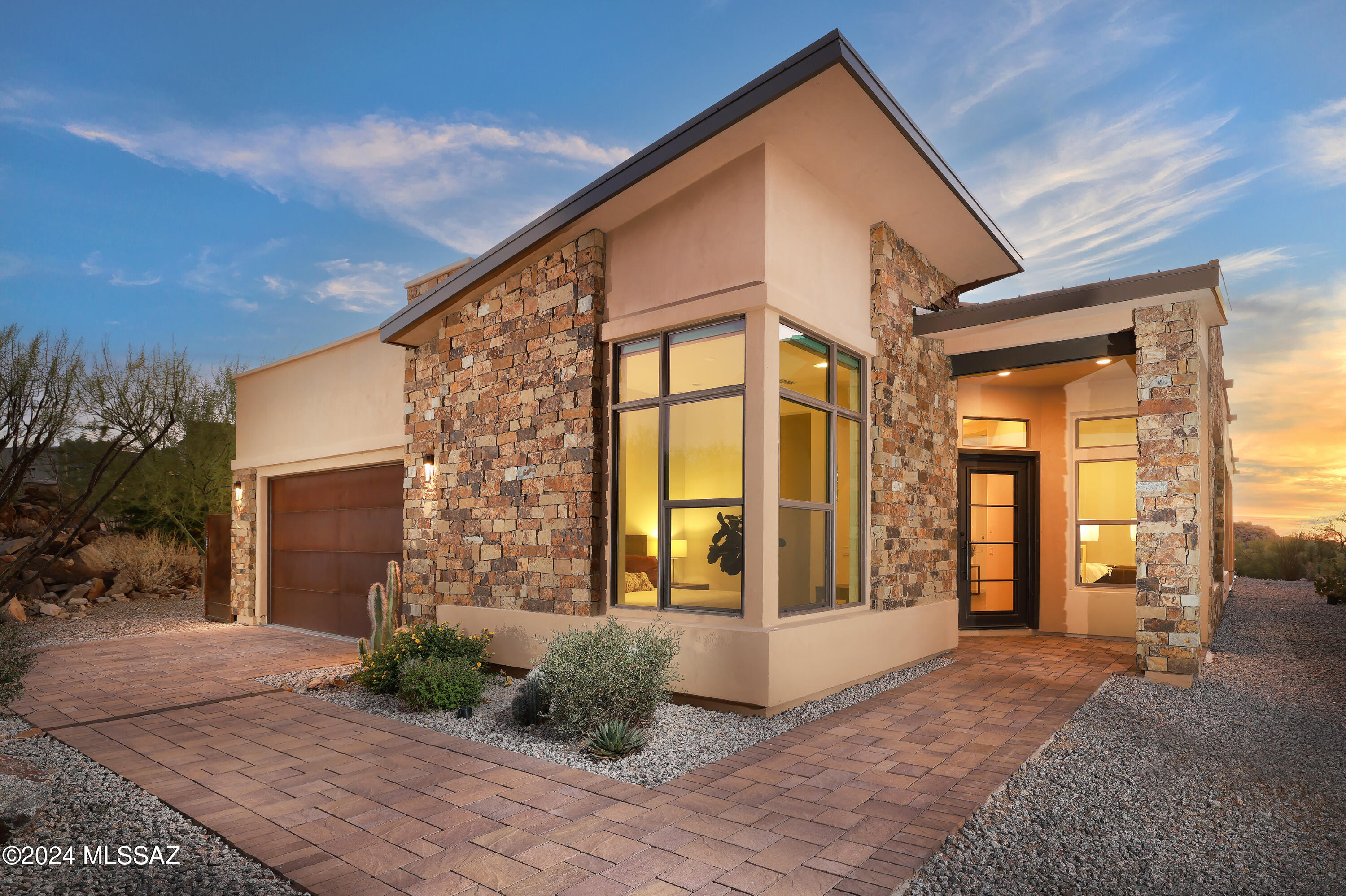 Set amidst striking rock outcroppings and towering saguaros, this prime cul-de-sac location offers unparalleled privacy, with your lot bordering a conservation easement for the ultimate in serene desert living.
Located in the beautiful gated community of Boulder Vistas at Stone Canyon. 
The paved driveway leads to a Contemporary entryway featuring stacked stone and metal accents. Interior lighting all replaced with Restoration Hardware for that polished modern look. A split-bedroom floor plan maximizes space and functionality, offering a perfectly sized home without compromising comfort. The upgraded kitchen serves as the heart of the home, boasting an oversized quartz island with breakfast bar, stainless steel appliances, a walk-in pantry, (click more) custom cabinetry and under cabinet lighting. An adjacent formal dining area is complemented by a bar room, complete with a wine cooler and extra storage.
The open-concept great room features large scale tile floors and walls of windows, perfectly framing the uninterrupted views. A large retractable glass door seamlessly transitions the indoors to a deep, covered wraparound patio complete with outdoor electronic shades, , offering a peaceful space to relax or entertain. The backyard is enhanced by beautiful pool & spa , a concrete & glass filled fire pit, and natural boulder enclosures for added privacy.
The primary suite offers serene views and a spa-inspired bathroom with an expansive glass-enclosed shower, dual vanities with ample storage, gorgeous tile flooring, and a walk-in closet. Two additional en-suite guest bedrooms include beautifully tiled showers with glass enclosures, while a flexible den space off the entry can accommodate an office or other needs.
Additional features include a well-equipped laundry room with storage and sink, and a two-car garage.  
Stone Canyon Lifestyle(As part of the prestigious Stone Canyon community, residents enjoy access to the award-winning Stone Canyon Club, consistently ranked among the top golf courses in the nation. Beyond the 18-hole Mickelson-designed course, the club offers a state-of-the-art fitness center, lap pool, tennis and pickleball courts, yoga and pilates classes, and luxurious spa services. All this, within easy reach of restaurants,