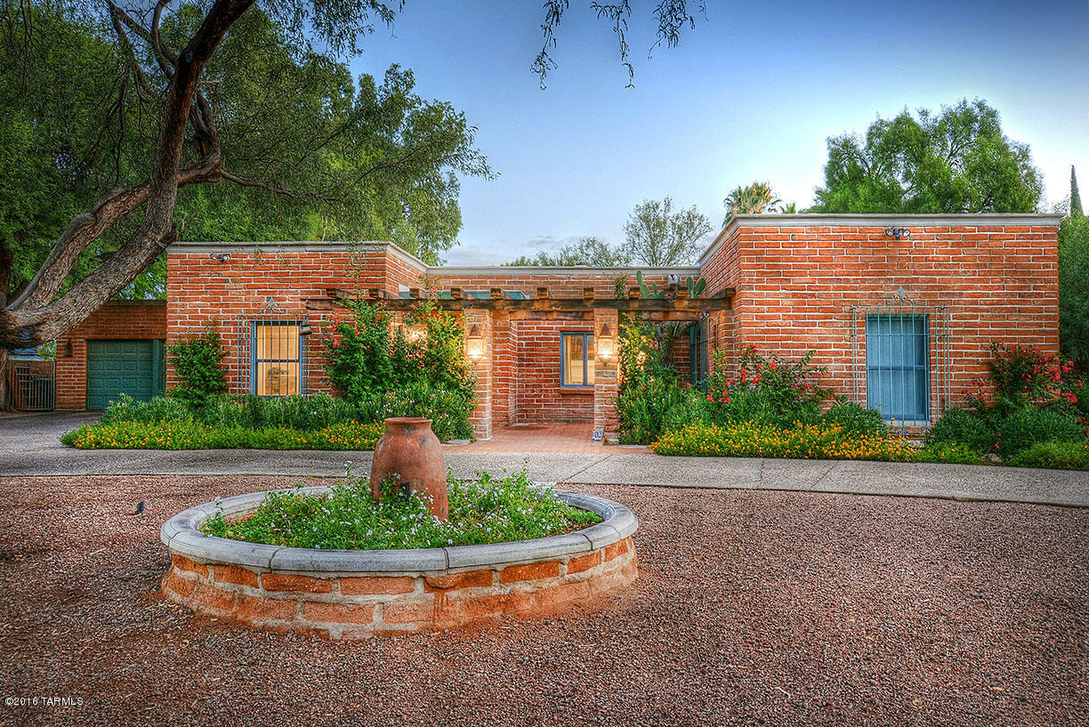 1955 Burnt Adobe Territorial home in El Encanto Estates on .50 acre! Dual pane windows,Original hardwood flooring,gourmet kitchen has brick floors,Wolf & Sub-zero appliances,center island & eat in area. 3 Large bedrooms in the main house, 2 bedrooms w/jack & jill bath,Master has private bath,Formal sep dining room,Large living room w/FP, Separate recreation room  & office, Separate familyrm w/built-in library & walls of glass framing a stunning Lush backyard oasis complete w/full outdoor kitchen,Cantera Fountain,fabulous Ramada w/fireplace,large pool w/private walled yard!Great separate 1 bedroom 1 bath guesthouse w/separate living room.Lots of storage throughout!3 car garage & tons of off street parking!Historic contributor has lower property taxes!