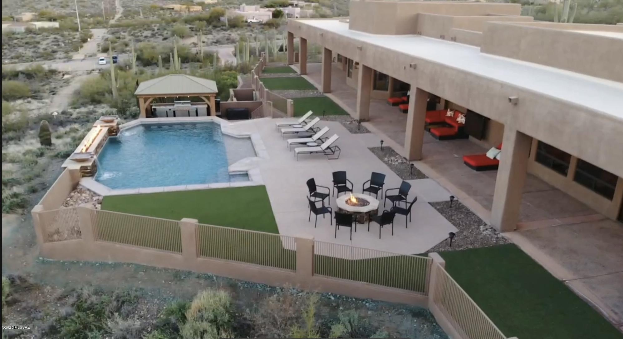 Spectacular Custom  9,500+ SF of indoor/outdoor living space. Situated on 3.37 Ac, this luxurious home that backs to Saguaro National Park, Entertain in style with your 24x30 Game Room w/Full Bar!  Home Theater with projection and surround sound, 3 tier leather seating included with this 6BR/6BA home! Formal Living Room, state-of-the-art Kitchen, Dining Room. Luxury  thru-out includes Travertine, hardwood, all alder doors, granite, stainless appliances, floating vanities, jetted tubs, walk-in showers and cove ceilings. Extended & Spacious 3-car garage plus 30x50 RV garage w/FULL hookups. Amazing City, Mountain & Sunset views plus heated pool w/swim-up bar, fire & water features all controlled by your phone. Full outdoor kitchen w/Gazebo.