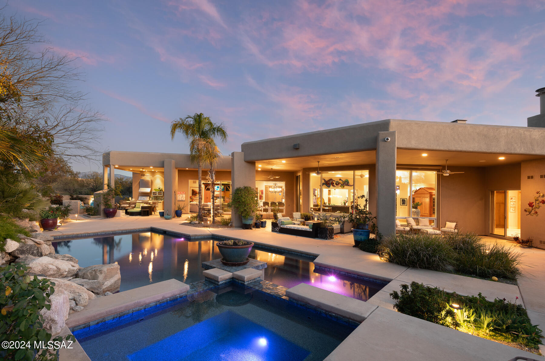 Exquisite, 2006 desert contemporary custom home situated on a pristine 1.25-acre homesite within walking distance of Sabino Canyon & minutes to Ventana Canyon C.C. This sanctuary-style cul-de-sac lot delivers sensational unobstructed mountain views & uncommon privacy coupled w/ thoughtful design & the highest quality materials for the ultimate in desert living. The circular driveway & large motor court lined with pavers lead to an inviting courtyard entry w/ a tranquil fountain. Metal framed glass front door & windows offer a clear view of the up-close mountain views through the wall of windows in the great room, maximizing the natural light & seamlessly merging the indoor & outdoor spaces. Great room has high ceilings & a mosaic tiled gas fireplace w/ custom metal doors. One-level home (no steps) w/ travertine & concrete floors (no carpet). High-quality materials & finishes include custom cabinetry, custom doors & trim, glass windows & doors, extensive built-ins in every room & automatic black-out shades throughout the home. A focal point for entertaining, the wet bar between the great room & kitchen is flanked by lit floating glass shelves and has a beverage refrigerator, ice machine & one-of-a-kind metal sink.  Modern chef's kitchen w/ custom-built cabinetry, stunning Azul blue granite countertops & custom backsplash. Huge center island w/ custom glass breakfast bar is drenched with natural light from 2 skylights above. Sub-Zero refrigerator & freezer, Viking oven & microwave, 5-burner gas stove, & SS hood. The large dining area off the kitchen has captivating mountain views. Expertly designed split bedroom floor plan has owner's wing complete w/ impressive primary suite w/ FP & exceptional views, truly luxurious spa-inspired bath w/ modern soaking tub, separate shower, large his & hers walk-in closets w/ custom built-ins & heated floors.  Bright office w/ extensive built-ins & an automatic dog door that leads to a dedicated dog yard/run w/ high wall. Powder room for guests. The guest wing has one en-suite bedroom w/ built-in shelving, a desk, a Murphy bed & a walk-in closet. Two additional bedrooms share a Jack & Jill bathroom. The family room off the kitchen has 2 walls of stackable glass doors that flow to an exceptional outdoor kitchen.
living & dining space w/ built-in BBQ, SS hood, sink, a built-in bar, a gas fireplace, banco seating, & a pool bath.  Over 1200 sf of covered patio wraps around the back of the house, providing several spaces to enjoy Arizona's indoor/outdoor lifestyle. Resort-style backyard w/ remote controlled pebble-tec pool, spa & waterfall w/ custom lighting.  The yard space is fully landscaped w/ desert plantings, trees & low-care turf. Huge laundry/mud room w/ built-in desk, sink, storage cabinets & drying bar. Walk-in pantry w/ built-in shelves. Extended-length 4-car garage w/ built-in storage. Enjoy the best of Tucson living with this convenient foothills location. District #16 schools (walk to Canyon View Elementary & Esperero Canyon Middle School). Minutes from great restaurants & shopping.
 
 
Nearby:
 
Sabino Canyon: Tucson's treasured recreational area with endless trails for walking, hiking & sight-seeing. Sabino creek runs through the canyon and attracts abundant wildlife. This lush & magical canyon is the best of the Sonoran desert.
 
Ventana Canyon Resort &  Country Club: Two 18-hole world-class golf courses, tennis, pickleball, lap pool, fun pool & workout room. 
 
Nearby shopping & restaurants: Bashas, Starbucks, CVS, The Commoner, Gavi Italian Restaurant, El Charro Mexican Food, Ginzu Sushi, & more.