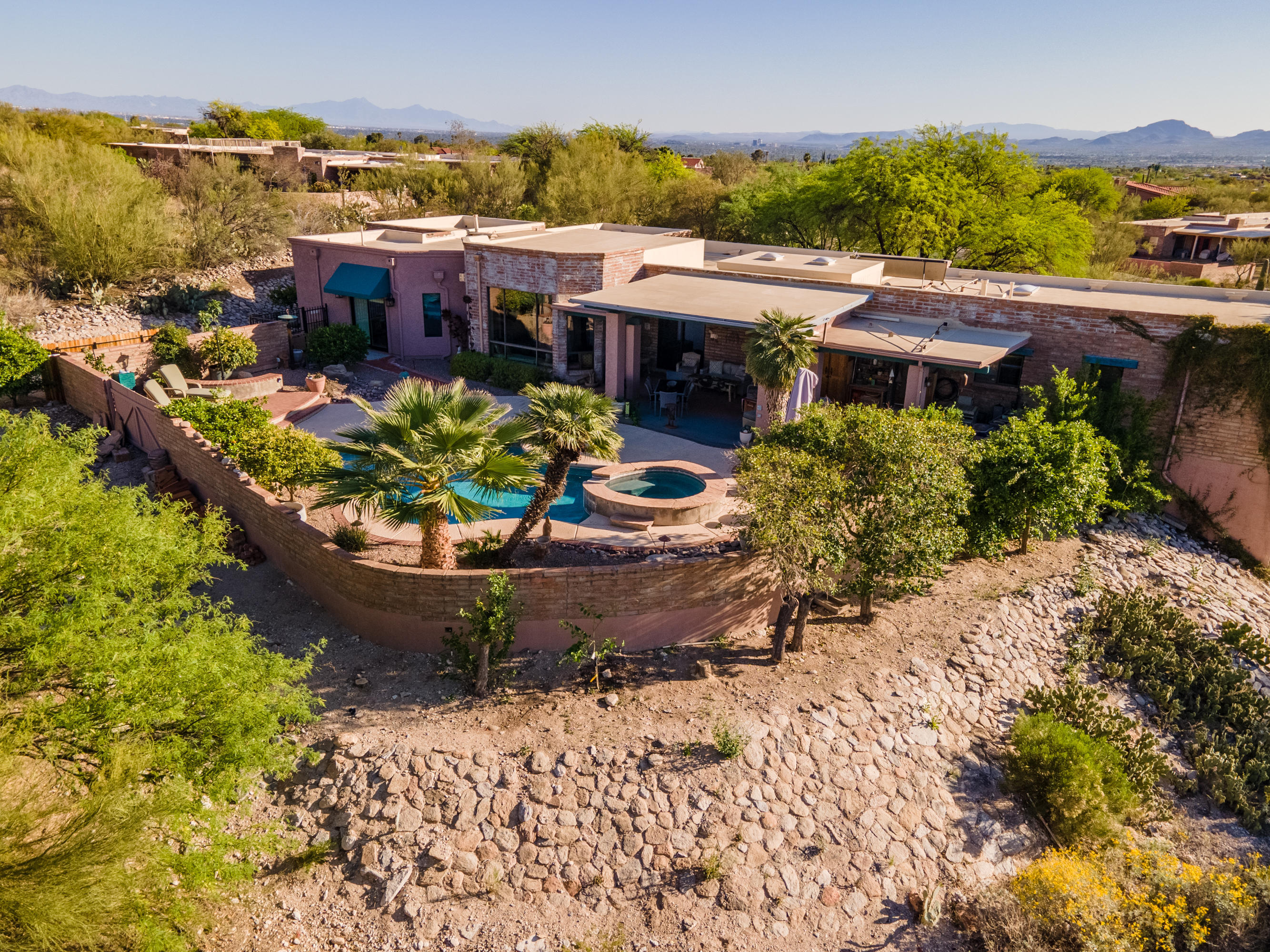 First time on the market! Custom Foothills home built in 1982 on a 1+ acre lot. 5BR+den flexible floorplan offers a split bedroom plan with two master suites and office space for everyone...see floorplan in the documents tab. Updated kitchen has custom cabinetry,large island with seating,Quartz countertops,double ovens,wine refrigerator, pantry, built-in desk and bookcases plus a view of the Catalina mountains! Kitchen opens up to a dining room and joins a large family room. Oversized three car garage has a mini split system for cooling/heating the garage & five storage closets...two are lined with Cedar. Garage is downstairs, all living areas are on the main level.  Incredible North facing mountain view + city views & sunset views from the front porch. Backyard oasis with pool/spa/BBQ. All bathrooms have been updated with custom cabinetry, tile or Quartz counters. Six Pella sliding glass doors throughout the home. Must see if you are looking for a centrally located Foothills home with privacy and views. Showings at the open house Saturday 4/17 and Sunday 4/18 from 12-4. After the open houses by appointment with your agent.