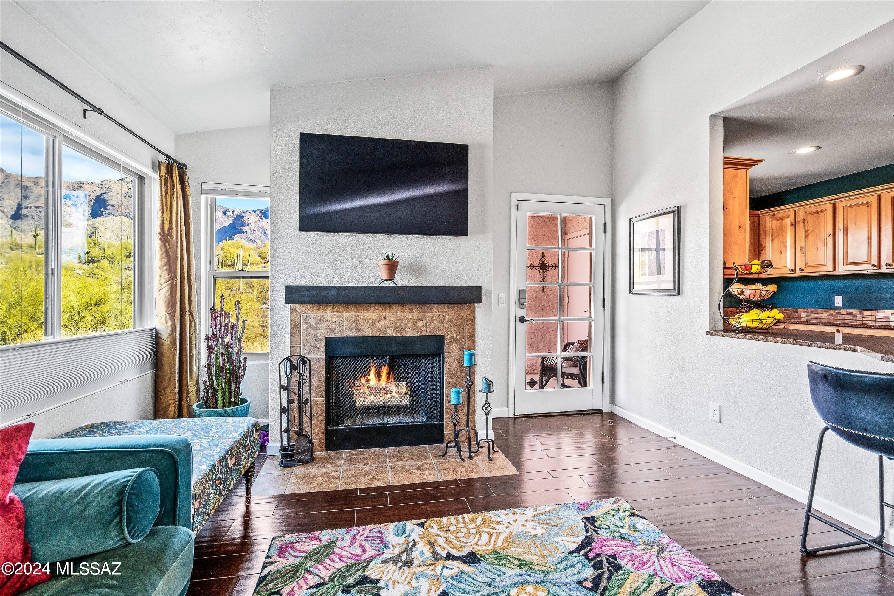 VIEWS VIEWS VIEWS! Incredible, unobstructed views of the Catalinas. Enjoy sunrises, sunsets and city lights from this rare ground floor end unit with no one above. This unique condo has a great floor plan that shows like a model with vaulted ceilings, woodlook tile and a cozy fireplace. The spacious galley kitchen has SS appliances, knotty alder cabinets, quartz counters and water softener/RO system. Recent updates include interior paint, window coverings, light fixtures, fireplace mantel, screens, storm door, HVAC (2023) and NO popcorn! Don't miss this hidden gem in a highly sought after location of the foothills. The community offers tennis/pickle ball court, fitness center, heated pool and is walking distance to La Encantada. HOA covers roof, exterior building, common area maintenance, trash and pest control. Nature is at your doorstep with hiking trails steps from your patio. The privacy and beauty can't be beat!
