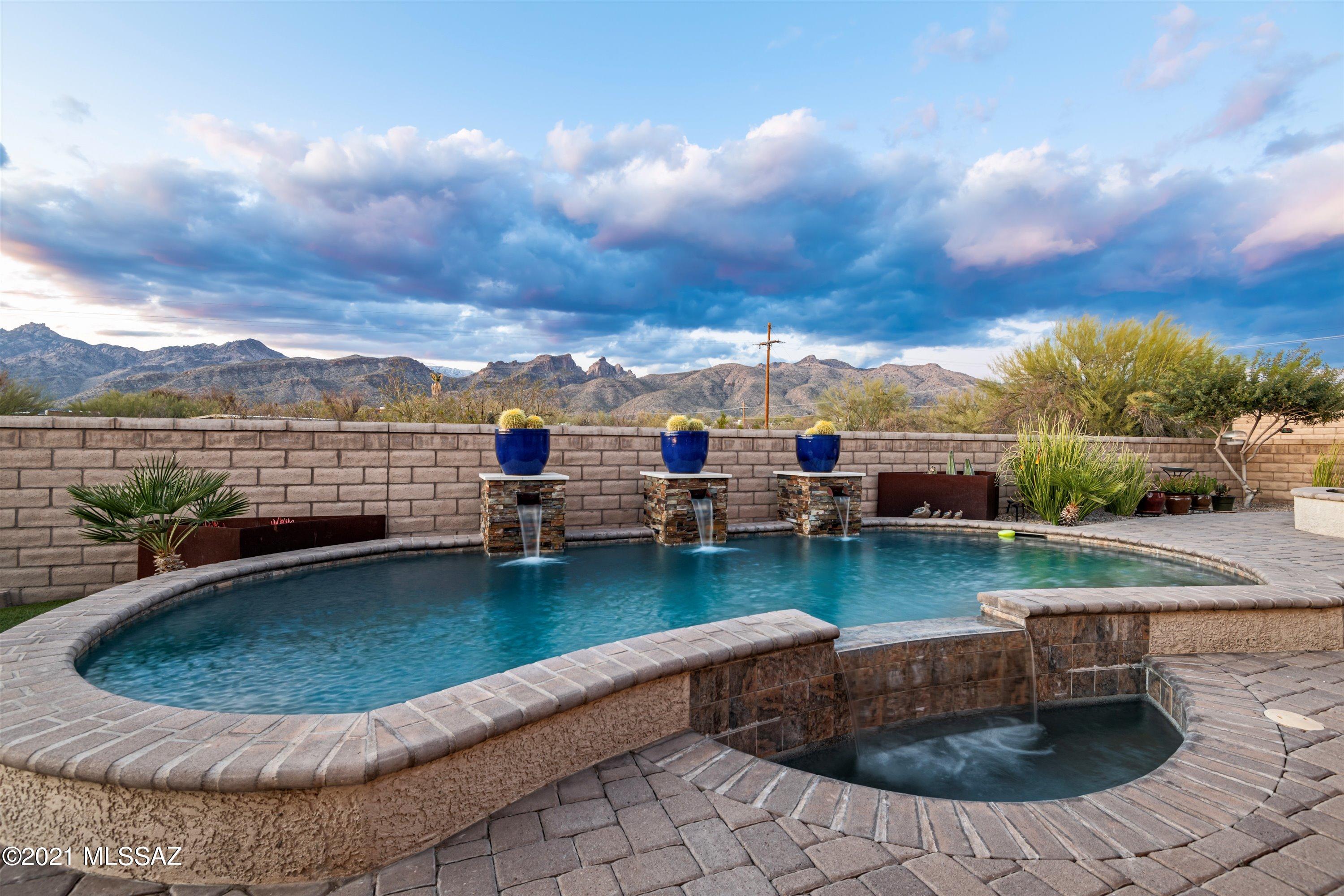 Rare opportunity to own a spectacular former Maracay model home!  The magic begins as you enter the courtyard, enjoy cool evenings in front of gas fireplace while listening to soothing sounds from unique water feature. As you enter through custom iron entry door you are greeted with breathtaking views of the Catalina mountains.  Popular Pinnacle floorplan has 5 bedrooms, 4.5 baths plus office & 3 car garage.  Versatile bedroom plan offers 2 full guest suites.  Gourmet kitchen w/oversized island & GE Monogram appl.   Huge great room w/custom faux copper tiled 12' ceiling, Restoration Hardware Chandelier  & 12' center pull doors lead to resort backyard for year round entertaining. Custom pool, pizza oven, firepit & swing add to the fun! Over 360K in builder upgrades plus pool & landscaping. Upgrades include: Casita w/entry from home & separate entry is a full guest suite w/walk in closet, or can be used as a studio, private office etc.  Knotty Alder doors and trim throughout, custom lighting, gourmet kitchen w/GE Monogram appliances including built in 42" Side by Side fridge, double wall ovens, 5 burner gas cooktop, upgraded granite and quartz countertops, upgraded Cherry double-stacked cabinets, custom backsplash, huge island with front apron sink, custom faucet & pendant lights.  Luxurious master suite w/sitting area, custom accent wall, faux beams, 2 large walk in closets & spa bathroom.  Master bath features walk in shower w/Raincan showerhead & 5' Kohler Oval freestanding tub.  Upgraded flooring & paint throughout.  Laundry w/cabinets & sink. Nestled in the Tanque Verde Valley within an hour's drive to the top of Mount Lemmon, one of Tucson's scenic destinations.  Mount Lemmon is a winter wonderland for skiers as well as a summer retreat.  Escape the summer heat while enjoying fishing & a picnic!
So much more....Full list of upgrades is attached in documents.