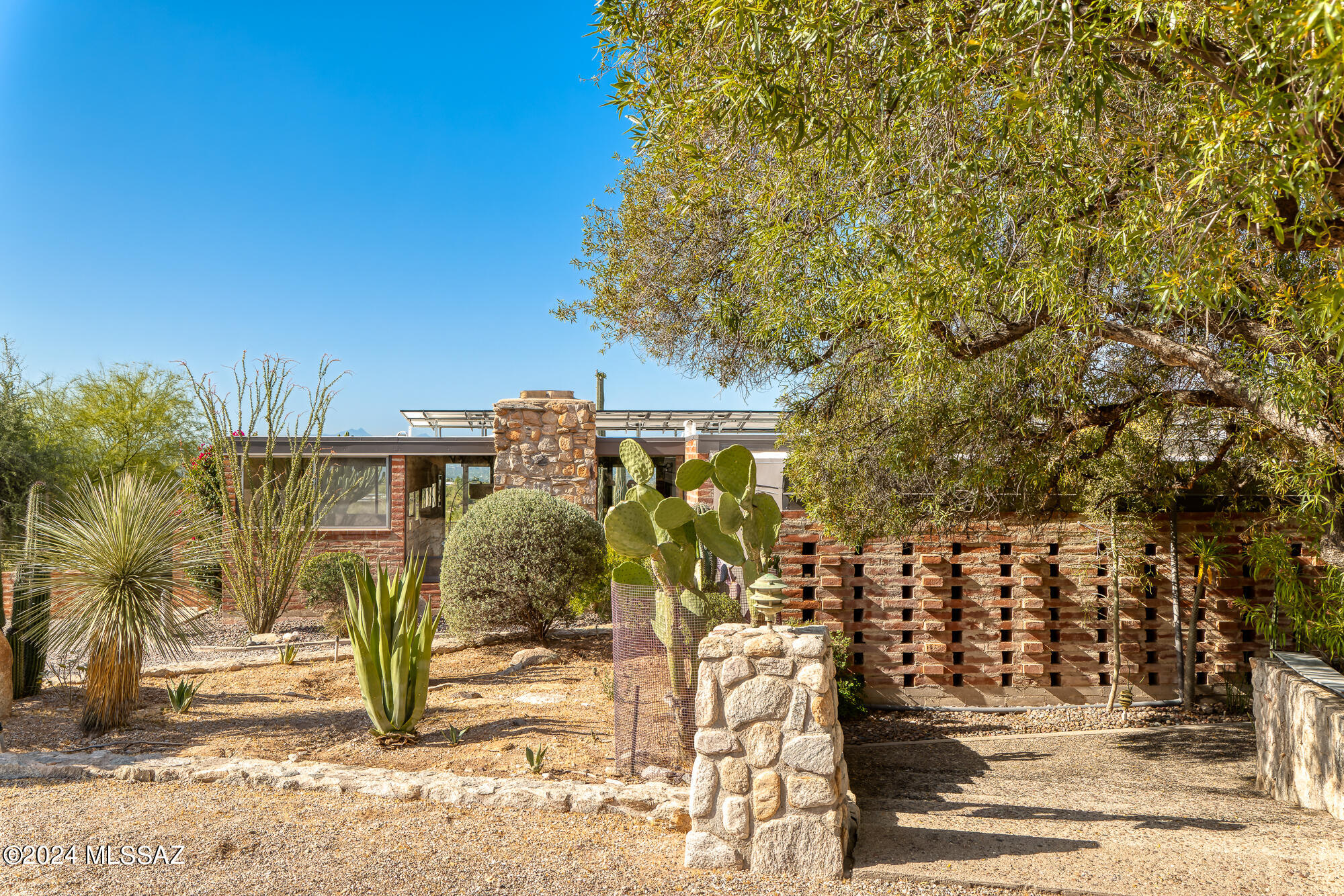 Perched on an elevated 1.2 acre lot in the Catalina Foothills, this 1962 Mid-Century Modern adobe home offers stunning mountain and city light views. Floor-to-ceiling glass walls on both the north and south facings emphasize the home's indoor / outdoor connection to its surroundings. The deep southern facing porch keeps the continuous ribbon of glass protected during the summer while allowing one to sit outside and contemplate the gardens, pool and desert horizon beyond. The central hub and communal space of the house is the kitchen, surrounded by living, dining and family room. The 4 bedrooms and 2 bathrooms are separated from the public areas by a main hall, ensuring privacy. The main bedroom is generously sized and features access to both the public patio & a private courtyard. A fireplace and an en-suite bathroom with a separate soaking tub and shower complete this retreat. The separate studio and laundry area / mud room are located near the attached 2 car garage.

A material palette of adobe, saltillo, concrete, glass and wood bring warmth and texture to the space. Meticulously maintained over the years, recent updates include leased solar panels, a newer HVAC system, water heater, dishwasher, and washer/dryer.

Located in a prestigious area within a highly desired school district, this home represents a rare opportunity. This home tells the story of a family who have shared many meals, memories, stories and sunsets that have shaped this house into what it is - a thoughtful observation on life.