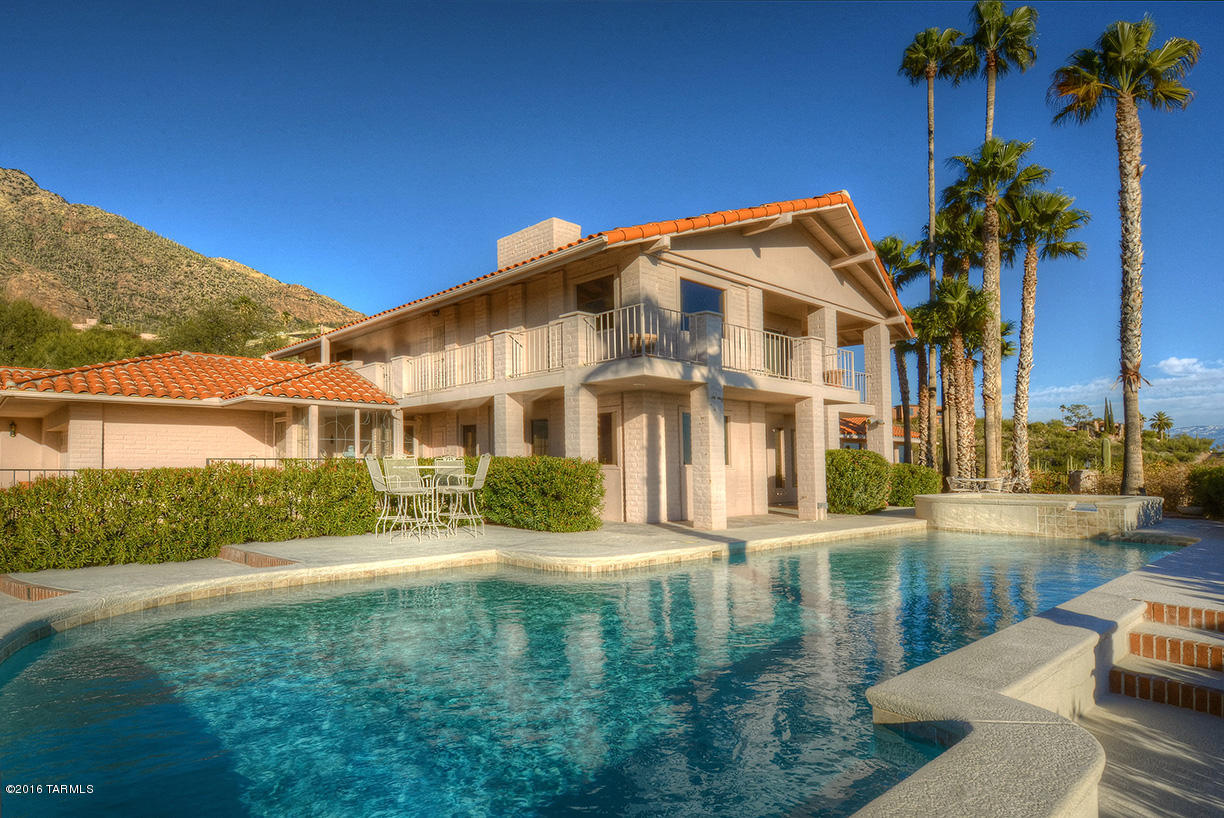 Set the stage for drama! Nestled in the Vistas of the Catalina's this secluded estate site at the top of guard-gated Skyline Country Club boasts panoramic valley views from east to west! Sparkling city lights can be enjoyed from the 12 person Jacuzzi or lap pool with total privacy. The drama of wood & space! This 5100 Sq Ft 5BR/5BA has Mahogany beams, moldings and carved doors exuding old world charm. Home includes completely separate guest quarters:with great room/kitchen, BR, BA all under same roof.