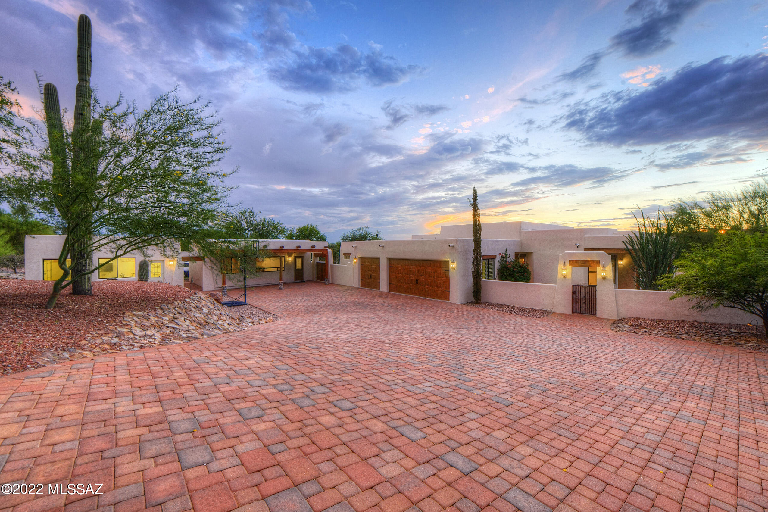 Stunning property in the heart of the Foothills offers space for the entire family and extended family. The main house with courtyard entry is 4 bedrooms+den+flex space, Great room off the kitchen plus a dining room and living room with Catalina mountain views. High ceilings throughout and a wood beam ceiling in the Great room. Kitchen has cherry cabinets, granite countertops Dacor 6-burner gas cooktop and oven. Two bathrooms recently remodeled. Three car garage attached to the house has storage+a sink. Separate 1BR/1BA guest house with living area. 23'x23' detached garage/workshop/man cave has AC & a wall mounted TV. Brick pavers  have been used for both driveways. Deep covered patio with built-in grill + a smoker, bar, pool & spa, artificial grass and an elevated seating area with views!