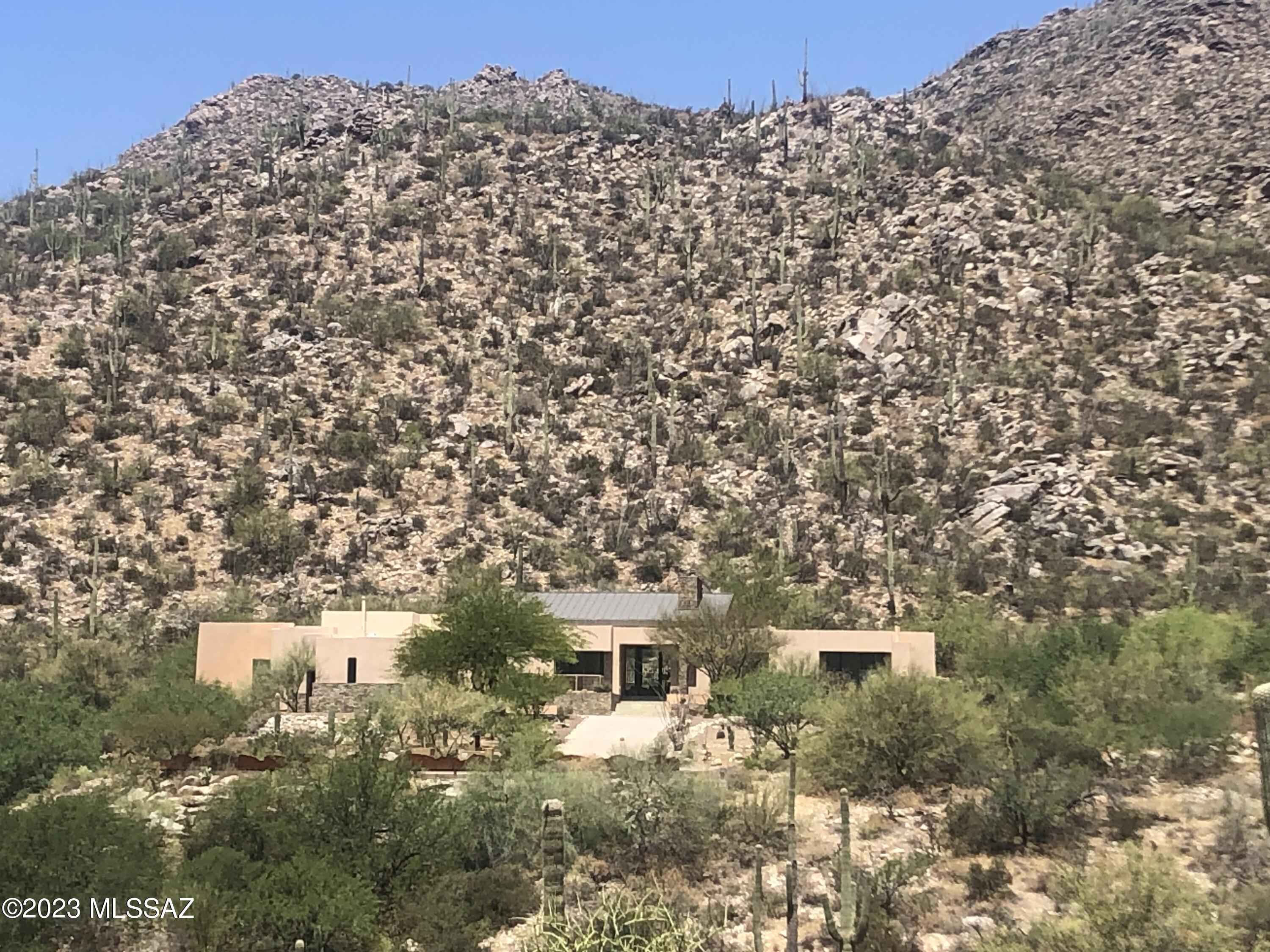 Stunning Modern Contemporary Kevin Howard Design. Walls of windows!  Sleek pool .Very private location within guard gated Canyon Pass at Dove Mountain. Great viewing from roof deck. Freshly painted interior.  Massive master bedroom. A plethora of great highlights.