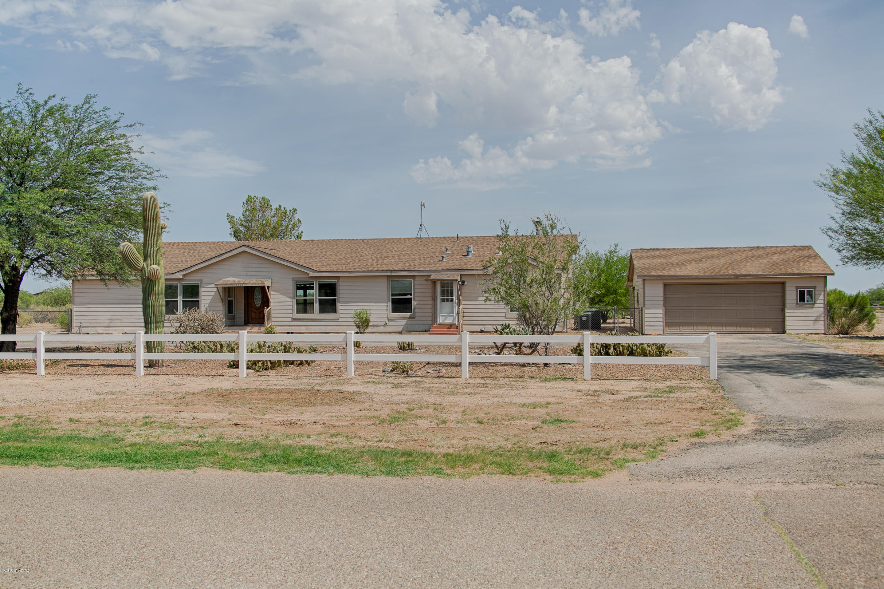 Back on the Market! Live the perfect country life in this newer 2964sf home on acre+ corner lot &  mountain views all around! No gravel roads here...paved streets take you to this permanently affixed 2003 triple-wide mftd home which includes an oversized 2-car insulated garage plus an attached 1-car carport. Huge property is completely fenced w/tons of room for your toys & hobbies. Massive kitchen has large pantry, pullouts in cabinets, & newer SS appliances. Kitchen opens to eating/dining room and big family room w/fireplace. Sliding doors & french doors from family room, kitchen and master BR all lead to extended back deck. Large master suite has dual vanities, big shower & dreamy walk-in closet w/custom built-ins. Two more bedrooms, a den, plus big laundry/craft room. 30-year roof.