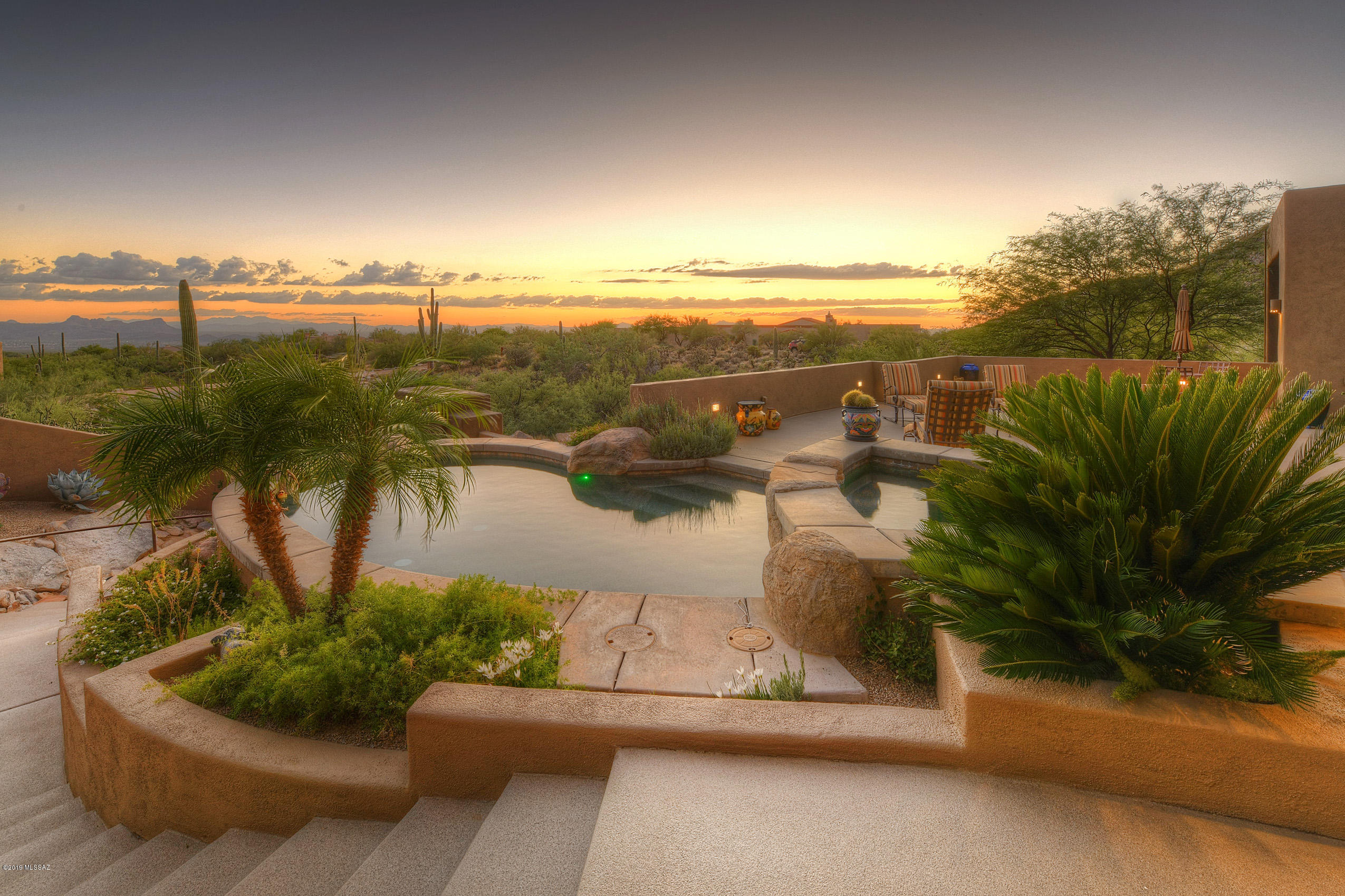 *ENCHANTING HACIENDA* WONDERFUL COMBINATION OF SW DESIGN W/ CONTEMP FLAIR! PERCHED ON HILLSIDE-BUILT INTO THE TERRAIN W/DYNAMIC MTN & CITY VIEWS!DRAMATIC ENTRY- WINDING PAVED DRIVE,THRU LUSH LANDSP, OVER A  BRIDGE -WONDERFUL APPROACH TO THIS ESTATE! *MAGICAL COURTYARD IS FILLED W/UNIQUE DESERT LANDSP/ WATERFALL...MEMORABLE ENTRANCE! ENJOY CASUAL LIVING- HUGE GREAT RM FILLED GLASS & VIEWS IN EVERY DIRECTION, SOARING CEILINGS, ELEGANT FP- OPENS TO KITCHEN! QUALITY CABS, LUSCIOUS GRANITE,BUTLERS PANTRY! RESORT BKYD- OUTDOOR KIT- ALFRESCO COOKING/DINING, COZY FIREPIT,  LAGOON STYLE POOL/SPA & BREATHTAKING MTN/CITY & SUNSET VIEWS! GUEST WING - ENSUITES, ELEVATOR, DEN/4TH BR, COMPUTER STATION, SOLAR SYSTEM. ''WALK THRU & DRONE VIDEO- ATTACHED*'' UPGRADES/FURNITURE 4 SALE* POSSIBLE TURN KEY!
