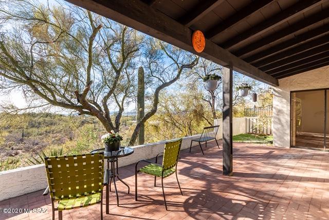 Single story 2BR/2BA plus den townhome in   Westward Look Guest Ranch on sought after corner unit view lot. Front patio captures beautiful views of Catalina mountains. Back patio, adjacent to large arroyo, overlooks natural desert w/sunset & city views.  Kitchen has informal eating area & breakfast bar. Living room incl  beehive fireplace & accesses back patio.  Den w/built-in bookshelves & desk could be 3rd bedroom. Master bedroom opens to back patio.  Masterbath has dual vanities. Year round heated community pool & spa. Club house has kitchen, sauna & bonus room (great for entertaining). 2 car garage. Walking distance to Westward Look Resort. Close to shopping ,restaurants & hiking. Make this property your own showcase.