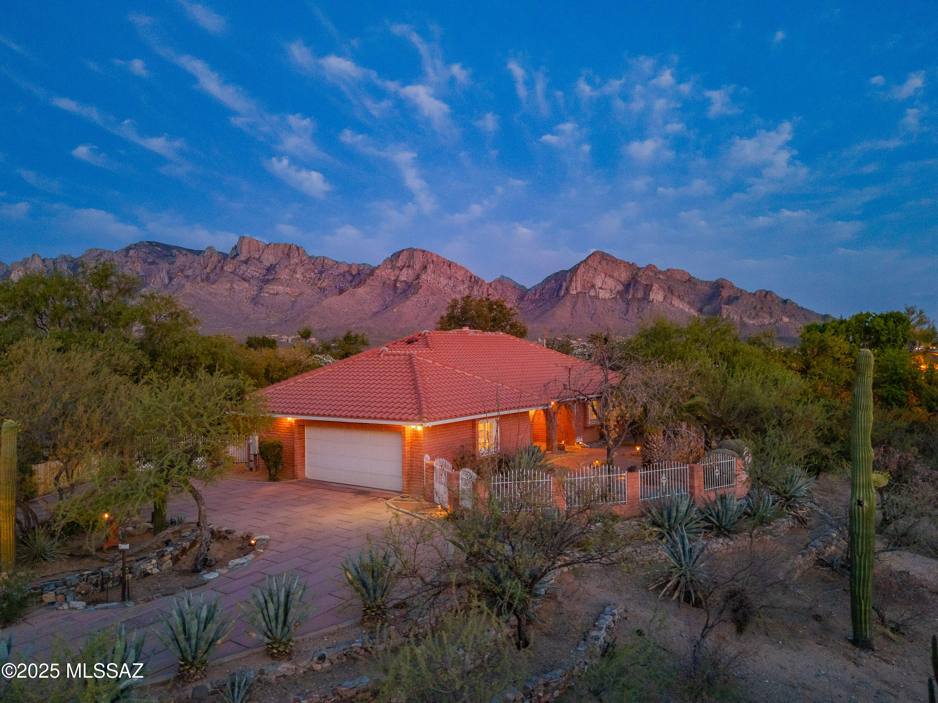 Ranch-style home in the heart of Oro Valley on a spacious 1.01-acre lot with stunning Catalina Mountain views. Located in desirable Tangerine Hills with no HOA, and adjacent to a natural desert wash for ultimate privacy. Gated front courtyard with pavers, fruit trees, and covered patio. Flexible layout with formal and casual dining, den/office, and laundry room. Kitchen features ample cabinetry, generous counters, and a coffee bar. Tile flooring and plantation shutters throughout—no carpet. Primary suite includes a walk-in closet and updated bath with barn door. Backyard oasis with heated pool, grass, mature landscaping, patios, shed, and RV gate. Oversized 2-car garage with storage and workshop space. Large circular driveway with extra parking.