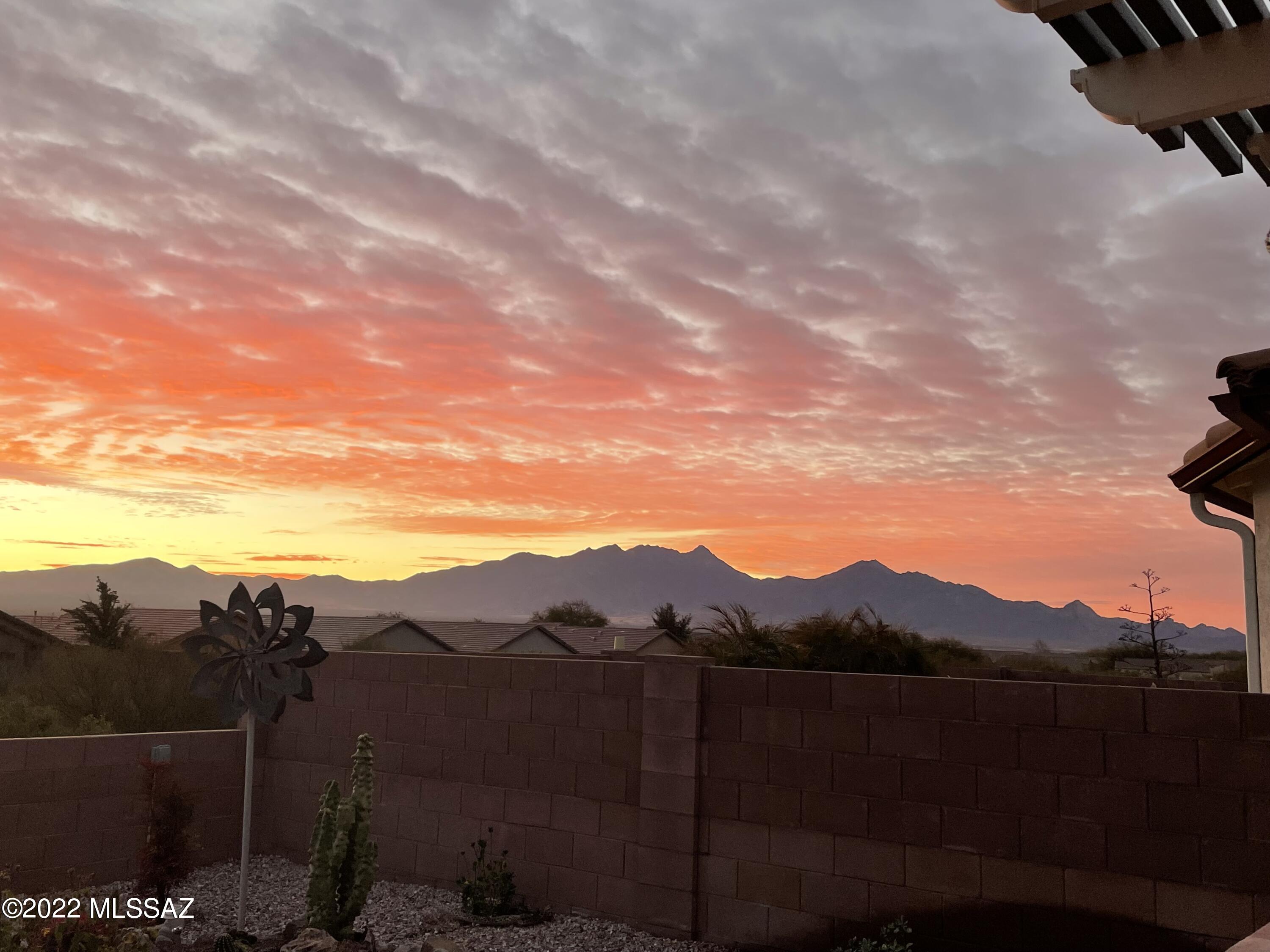 From the moment you walk through the front door & find yourself lost in the breathtaking mountain views in back...it will be love at first sight!  The outstanding great room floor plan is built the way you want to live and entertain.  Full of natural light with neutral shades of paint throughout and tasteful décor.  Best of all everything that is in the house conveys with it.  

Among the countless features are a den with a wall bed, Hunter Douglas fans & window shades throughout,a Bay Window in the primary suite and, whole house filtration system. The kitchen, which opens to the great room, has a pantry, granite counters, reverse osmosis, a breakfast bar, a Samsung range and is wired for gas.     

Outside you'll find pavers along the sides of the driveway, down the side of the garag and in back, that extends the patio. There is a paver pad that is wired 50 amp 220V and plumbed for a hot tub.  The extended garage has floor to ceiling cabinets as well as a custom cupboard for storing golf clubs.  HERS rating of 62 makes it 38% more energy efficient.

If you are looking for southwest outdoor living at its very best...look no further! The ramada extends the covered patio giving plenty of space to entertain friends and family.  There is a built-in barbeque outdoor kitchen with a grill, refrigerator, and bar area.  Your front row seats to the ever-changing Santa Ritas are magnificent and you'll never grow tired of watching their colors change!