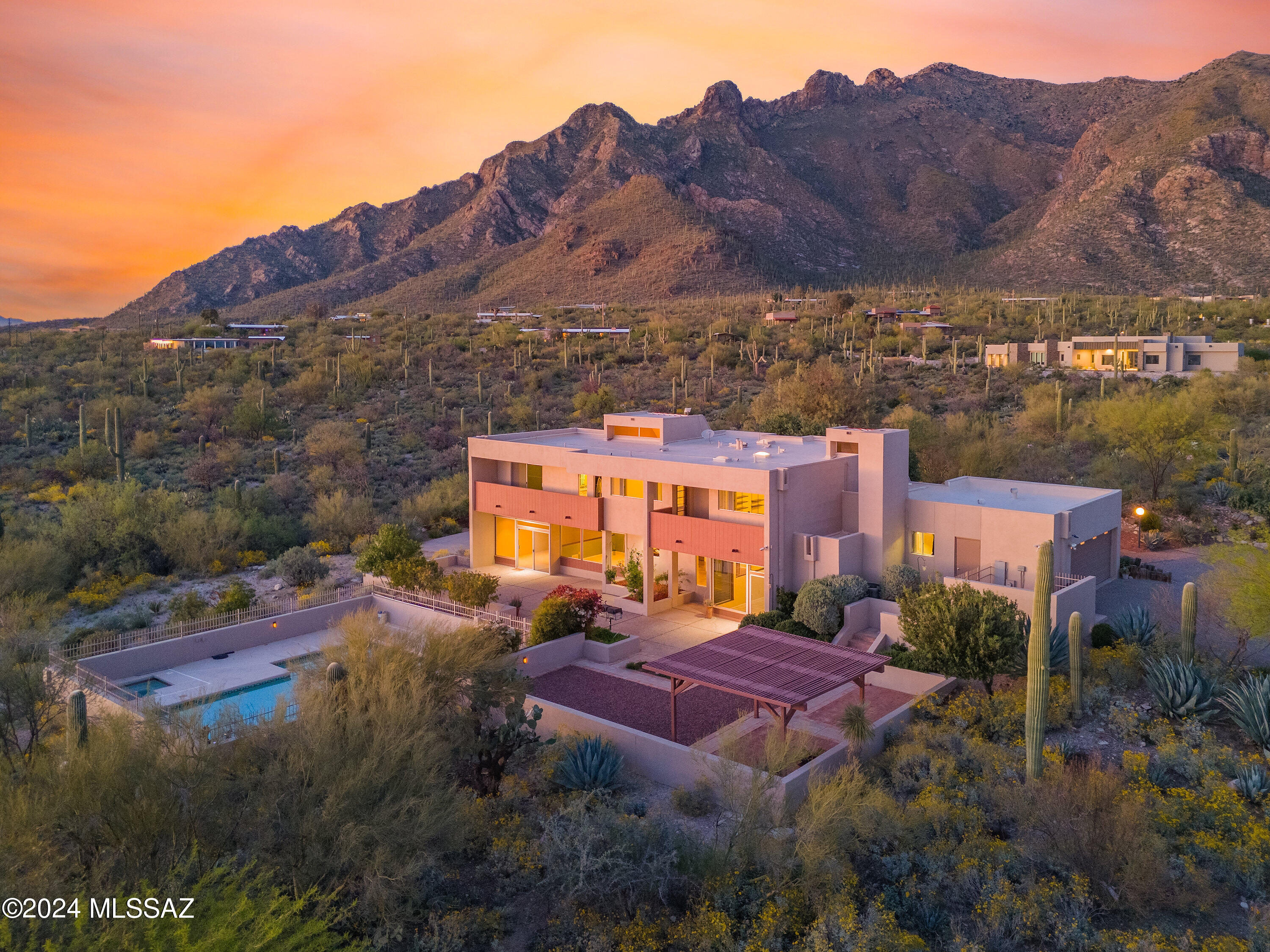 Nestled in the Catalina Foothills, architecturally significant one owner home by noted architect Earl Kai Chann on a 4.9 acre lot.  Private gated driveway leads to a lovely front walkway occasionally visited by a pair of big horned owls.  House set to capture mountain scenery, city views; spectacular Arizona sunsets from porches/patios throughout.  Mid-century design elements enhance the entrances; the gathering spaces in the living, dining, breakfast, family rooms, offer an open airy flow.  Spacious laundry room; plentiful storage space a plus. Built-ins, fireplace, wet bar, easy access to poolside enrich the family room.  The pool, spa, ramada echo the defined shapes of the home.  Zoned for horses.  Neighborhood convenient to UofA, downtown, Pima Canyon.