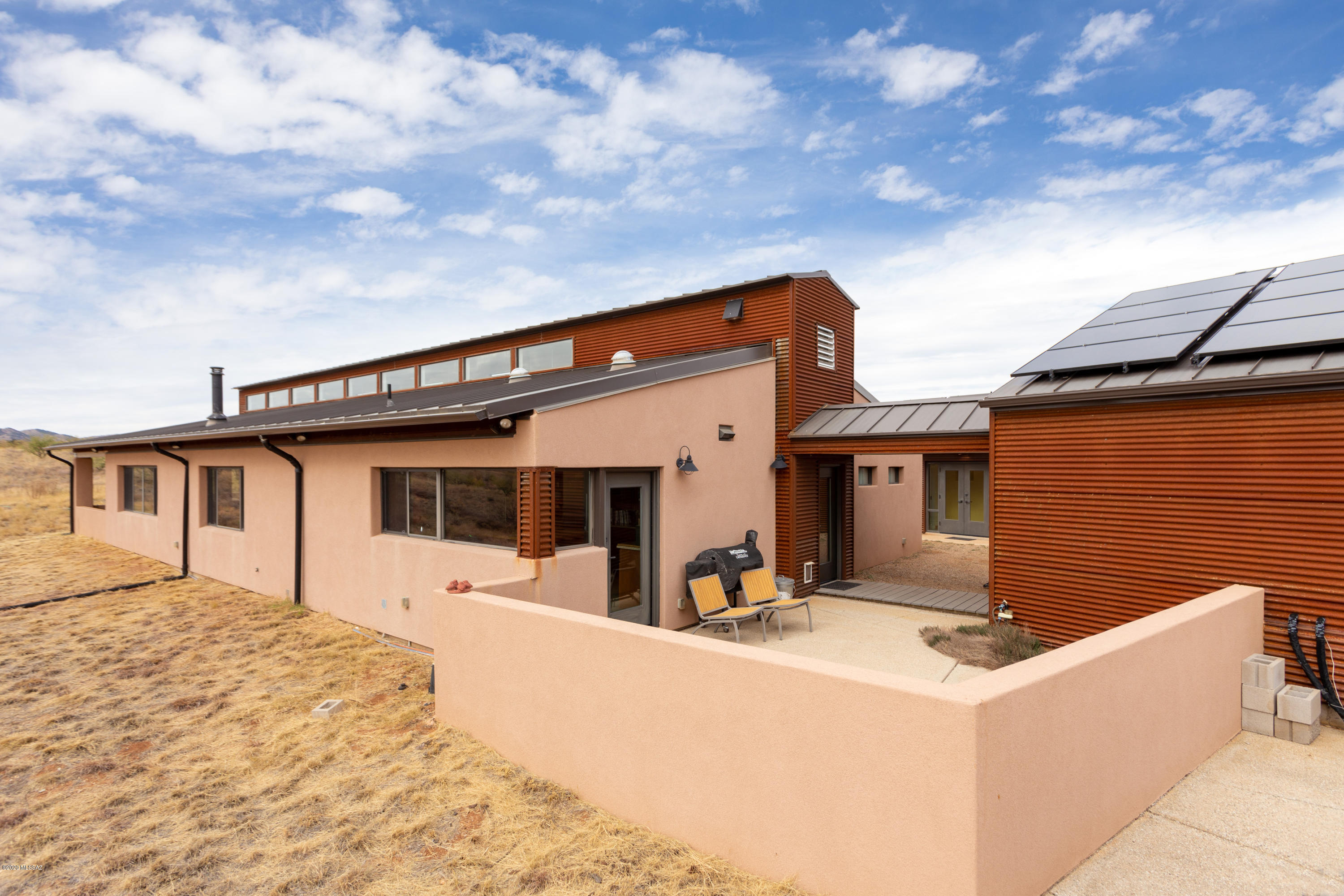 Meticulously designed energy efficient state of the art passive Solar, all electric, grid tide, Integra block home w/standing seam metal roof. Directly borders Nat'l Forest, 360 unobstructed  Views of surrounding MTN ranges, rolling mesquite and oak studded grasslands. Hidden Hills esteemed gated community, UG power, 3 Br main house w/exercise room. 1 Br Guest house. Chefs dream kitchen, Radiant floors, Highly efficient woodstoves keeps the house cozy in winter. A powerful  Whole-house fan located high pulls cool air & earth-cooled air (Earth tubes) Thru-out, 2 Heat pumps(supplemental HVAC), clear story windows, retractable rolling screens over French doors, SS appliances, 3 patios, Rainwater harvesting (Three 3k gal storage tanks) feeds irrigated garden & oak trees. Easy commute to Tucson