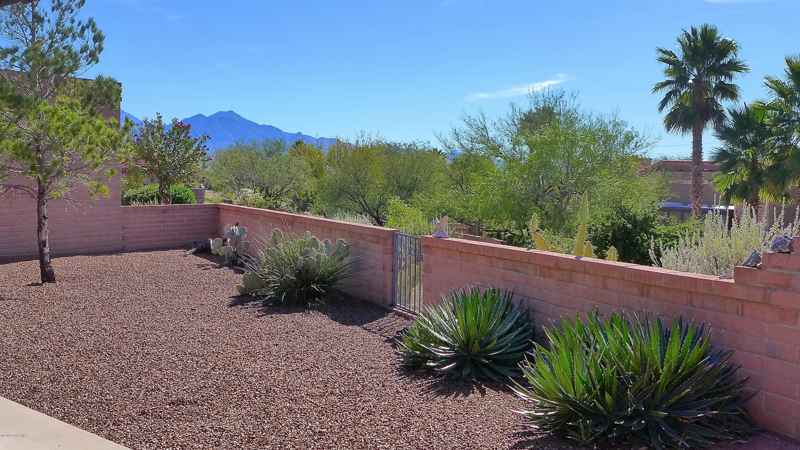 This one owner home has been gently used as a part-time home since it was built and is being sold fully furnished as shown. It boasts mountain views & a lush common area behind it for added privacy. You'll enter the home through a courtyard entrance & once you step inside, you'll find a home that looks almost as good as the day it was built. The centerpiece of the large living/dining room is a Kiva fireplace which has gas to it but no gas logs. Efficient galley style kitchen opens to a space that can be used as a den or family room. You'll love all the windows and sliding glass doors which bring in the light from the South facing backyard. In back you'll find a wrap around patio & plenty of areas both covered & uncovered from which to enjoy the view of the ever-changing Santa Ritas