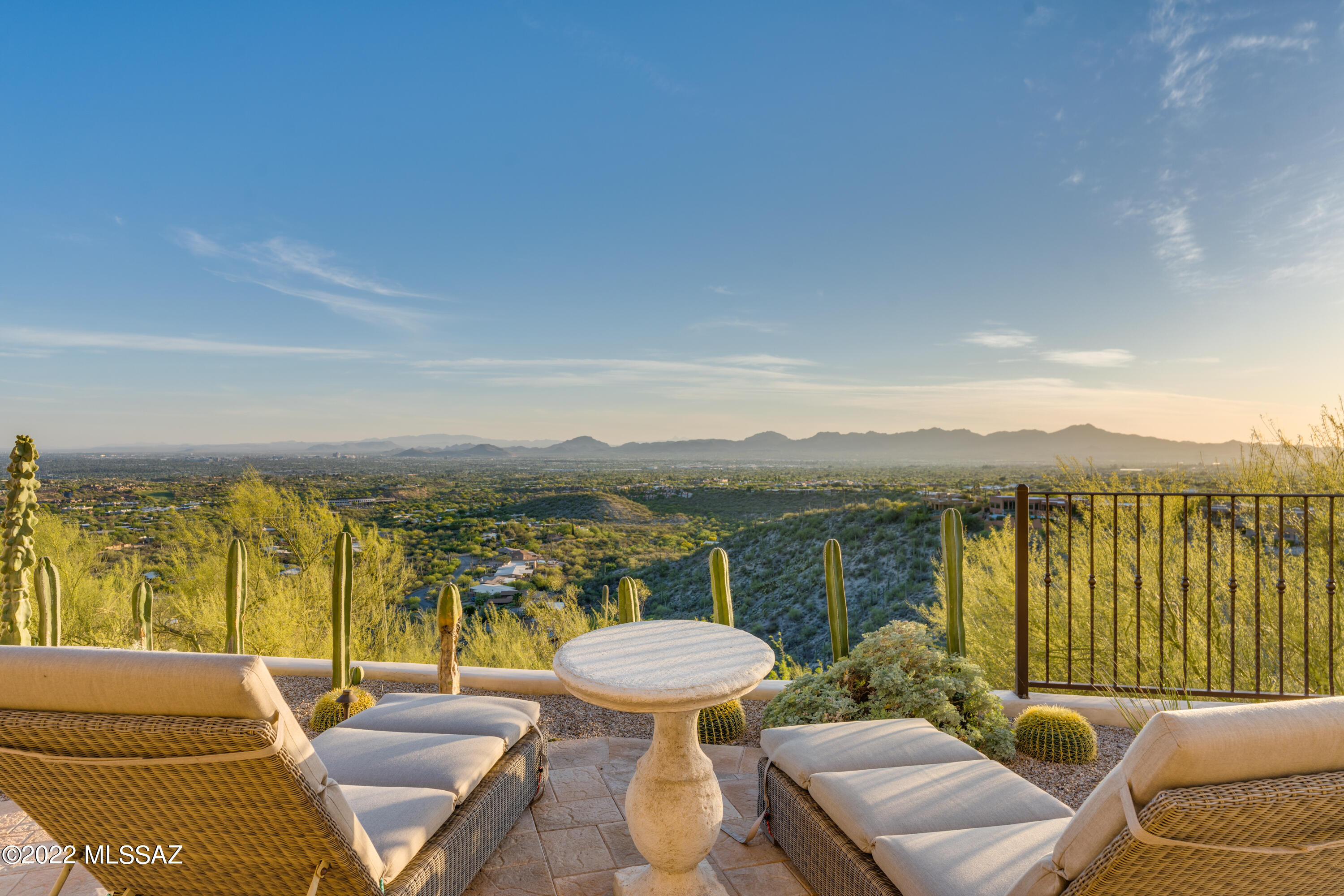 This stylish and inviting rustic contemporary sits on what feels like the top of the world, surrounded by mesmerizing, wide-open views of the majestic Catalinas, the entire Tucson Valley & its dazzling city lights, and Tucson's spectacular sunsets. Imagine experiencing Tucson's sensational monsoon season from this limitless vantage point! With a perfect North/South orientation, this home enjoys soft, indirect, natural light and features a comfortable floor plan with authentic architectural details including gorgeous reclaimed wood and authentic Mexican tile floors, wood beamed ceilings, doors, and fireplaces,and so much more. Blurring the line between indoors and out, there are many inviting and comfortable rooms and spaces to gather for meals, entertaining, relaxing, working, and playing. The richly appointed kitchen with top-of-the-line cabinetry & appliances plus ample space for prepping and enjoying meals is sure to be a favorite. The main entry level includes the kitchen, open dining & living room, the primary bedroom suite & a 2nd bedroom & bathroom. Downstairs features a large, well-equipped laundry room, 4 additional bedrooms, and 2 baths. Beyond the extraordinary interior, the gorgeous backyard features a luxurious pool and spa with waterfalls, meticulous landscaping, a putting green, and a full outdoor kitchen with alfresco dining space. 
The photos speak for themselves - and say it much better than I can - so, if you like what you see in the photos, you will LOVE what you see in person...a gorgeous & inviting home with panoramic views situated on a quiet, private lot in gated Foothills ll (central foothills), convenient to the best of everything the Catalina Foothills has to offer.

For a closer look at how this property came to be what it is today, Gene Kniaz, the founder of Spiral Architects offers valuable insights into the goals and tasks involved in the renovation of this property >> https://www.houzz.com/hznb/projects/tucson-foothills-renovation-pj-vj~816558 <<