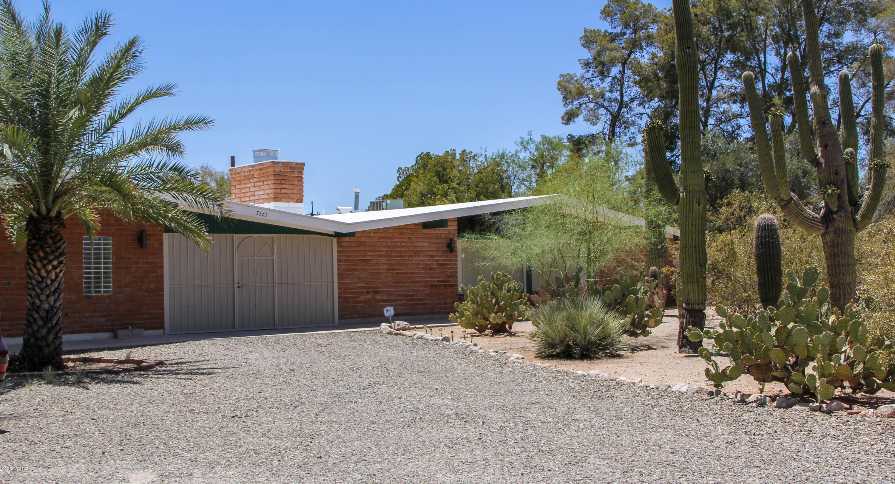 Hard-to-find beautiful saguaro studded property on almost an acre with a home and large casita. This Mid-Century Modern home has been tastefully remodeled and also has a casita that's over 900 square feet for your parent, business, or visitor. You can even park an RV at the property. Sit outside under the huge covered & screened-in Arizona room while listening to the sounds of nature. There's even a voluntary community pool membership if you want to enjoy those summer swims! With all the mature saguaros, palms and pine trees you may feel like you're out in the country, but it's only minutes away from Whole Foods, top rated restaurants, and all the amenities of the city.