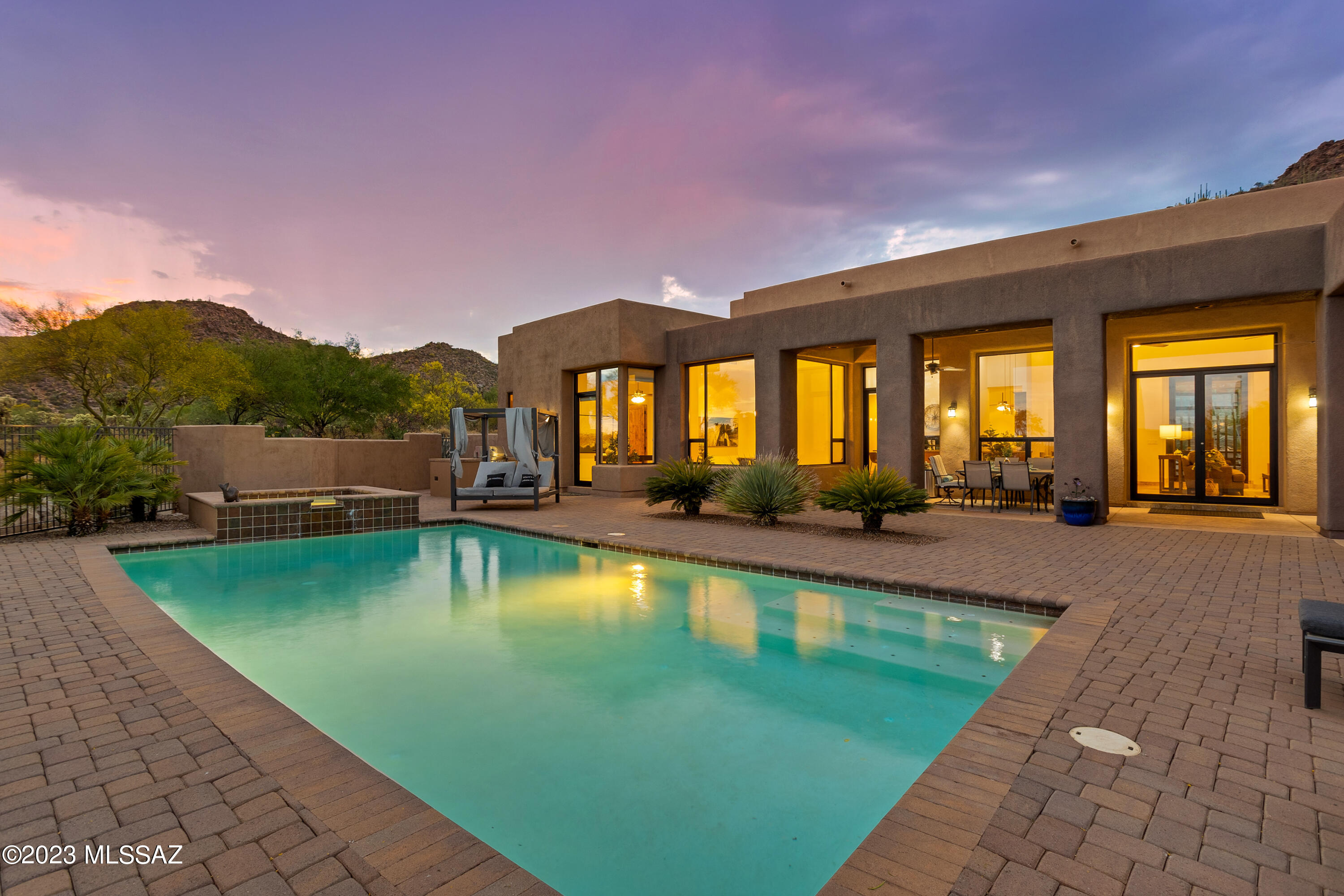 This spectacular luxury home is snuggled down into the canyon to maximize privacy and mountain views on all sides from every room!  Relocating sellers have priced this beautiful 4,453 sq ft, 4 bedroom home significantly below what it could be built for today!  With an open floor plan design, expansive windows flooding this home with natural light, travertine floors, sound system throughout the inside of the home and outside, large bedrooms, private pool & spa and a 1,121sq ft garage with A/C, epoxy flooring and an abundance of workshop cabinetry - this property is sure check off All of your Must Haves!  Elegant iron & glass front doors open the way into a great room with fireplace and immediate gorgeous desert views.  As you make your way into the spacious gourmet kitchen you will find... Thermador gas cooktop, separate oven w/ rotisserie options, warming drawer, large individual stainless steel refrigerator, freezer, and beverage cooler, plenty of granite countertop space for cooking and entertaining and tailored cabinets featuring custom pullouts.  The kitchen nook is surrounded by windows for you to revel in the breathtaking scenery while you sip on your morning coffee.  A graciously sized formal dining area with built-ins can be utilized either for dining and/or a considerable home office option.  All of the bedrooms in this luxury home are impressively sized, three bedrooms have private en suite bathrooms featuring easy walk-in showers & granite countertops.  Relax inside your luxury master bedroom oasis, with fireplace, sitting area, master covered patio and breathtaking evening views of the sun setting over the mountains as you end your day.  A spa-like master bathroom has a large jetted tub with cascading rainfall spout, immense walk-in shower complete with body, rainfall & traditional shower options, dual vanities and impressive master closet with custom built-in system!  Within the master en suite, is a separate owner's laundry, too! Open up the grand double glass doors off of the living room to combine your indoor and outdoor spaces!  Fully enjoy your private 1.36 acres of saguaros, professional landscaping, extra guest parking, extensive covered patio areas with ceiling fans for outside dinner parties with unparalleled views, heated pool large enough for all of your family or friends, spa, gas grill & bar top dining space, too.  Welcome to 13964 N. Copper Sunset Drive - Your Dream Home!