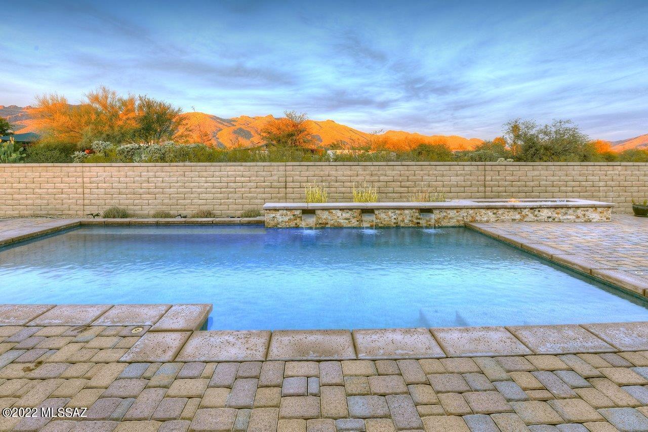 Beautifully upgraded home on a premium lot with fantastic mountain views. Enter through the private courtyard into this gorgeous home. Open floor plan, soaring 10' ceilings, abundant natural light throughout, & great room w/custom fireplace. You'll love the chef's kitchen w/large granite island, gas cooktop, double ovens, walk-in pantry, & lots of cabinets. Split floor plan w/4 BD + office & den, & 3 BA. Spacious primary suite has a huge walk-in closet, & a spa-like bathroom w/soaking tub & separate shower. The great room has 16-ft wide sliding glass doors that open to the resort-like back yard w/covered patio, sparkling pool, & beautiful desert, city & mountain views. LEED Certified Home. 3-car garage. Conveniently located near Arizona National Golf Club, walking trails & more.