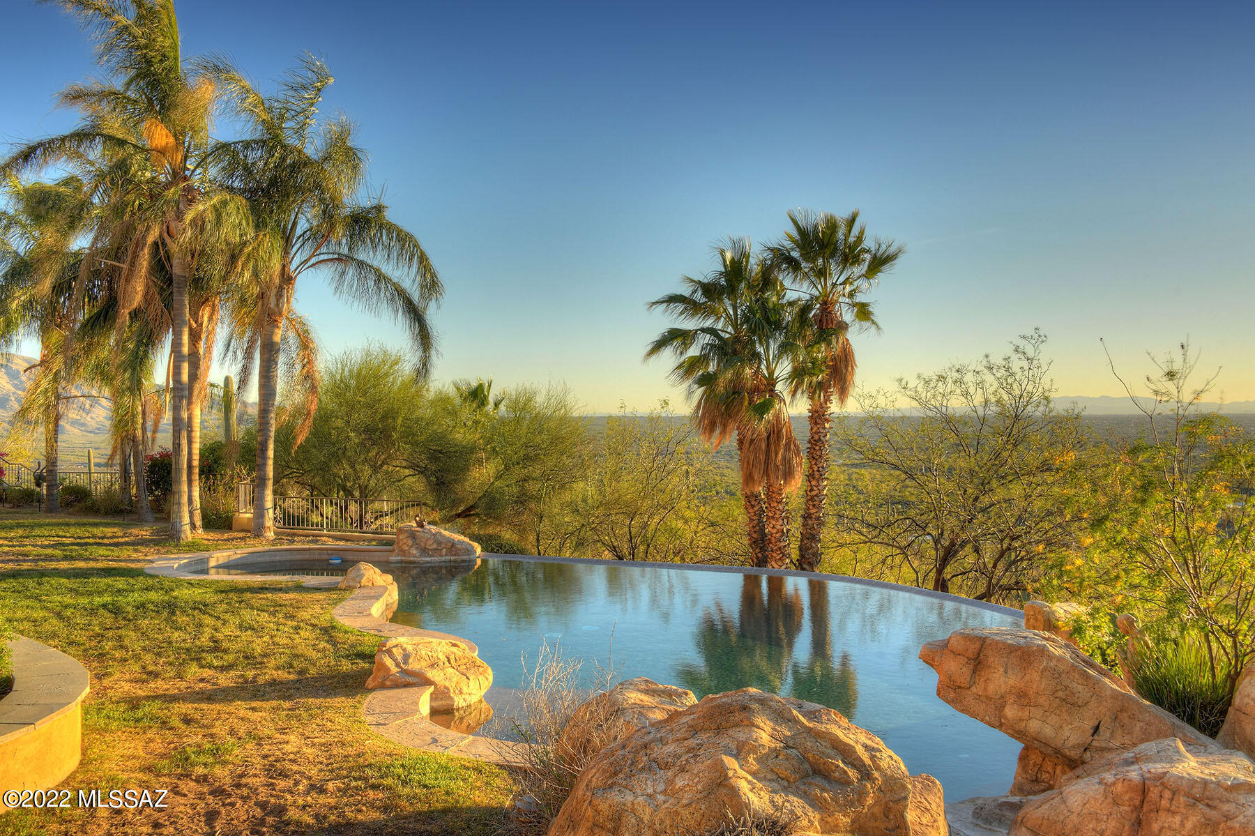 Rare opportunity to own a hilltop residence with 360 degree views on 3.7 acres.  This palatial estate has it all:  over 4500 sq. ft. of elegance: Handcrafted wood, wrought iron, copper and natural stone floors of the highest quality throughout home.  Spectacular 4 sided fireplace with hammered copper hood sets the tone. Elegant formal dining room to wrap around patios for dining options.  Kitchen is a chef's delight with commercial size Viking stove, hand crafted cabinetry with burled wood inserts, prep island, 2 dishwashers & full butler's pantry with wine fridge and storage.  Two owners' suites with sitting rooms are grandly proportioned with fireplaces, jetted tubs, spacious showers and well-thought out closets. Pool and spa will compete with the views for attention.  3 ½ car garage has room for 5 cars complements of 2 car lift bays.  Don't miss the full size bocce ball court, fire pit with banco seating as you explore the grounds. The gated community of Redington Ranch has a lake, stables, horse trailer storage, pool, tennis & club house.