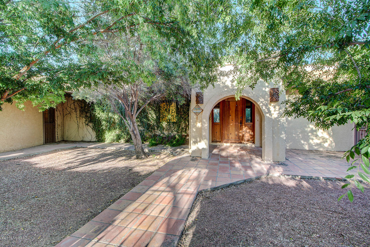 Home sold AS IS, sellers have no intention of making repairs.  This 5446 sq ft home sits on 1.09 acres & offers lots of rooms & storage space including a library, 2 offices, den and hobby room.   Main entry leads you inside to spacious living room with high ceilings & exposed beams.  Master Suite features sitting area, 3 closets & large bathroom.  Spacious Arizona room (1,165 sq ft, not counted in the 5,446 sq ft of the home) has a fireplace.  Kitchen opens to cozy family room with fireplace.  Step outside to the covered patio overlooking the pool & Ramada.  Five additional bedrooms with optional 6th bedroom or den, allows plenty of space for guests or large family.  Backyard has a breeze way, 1-car garage, 1-car carport, metal building, 2 sheds, basketball hoop on a patio, and play house.