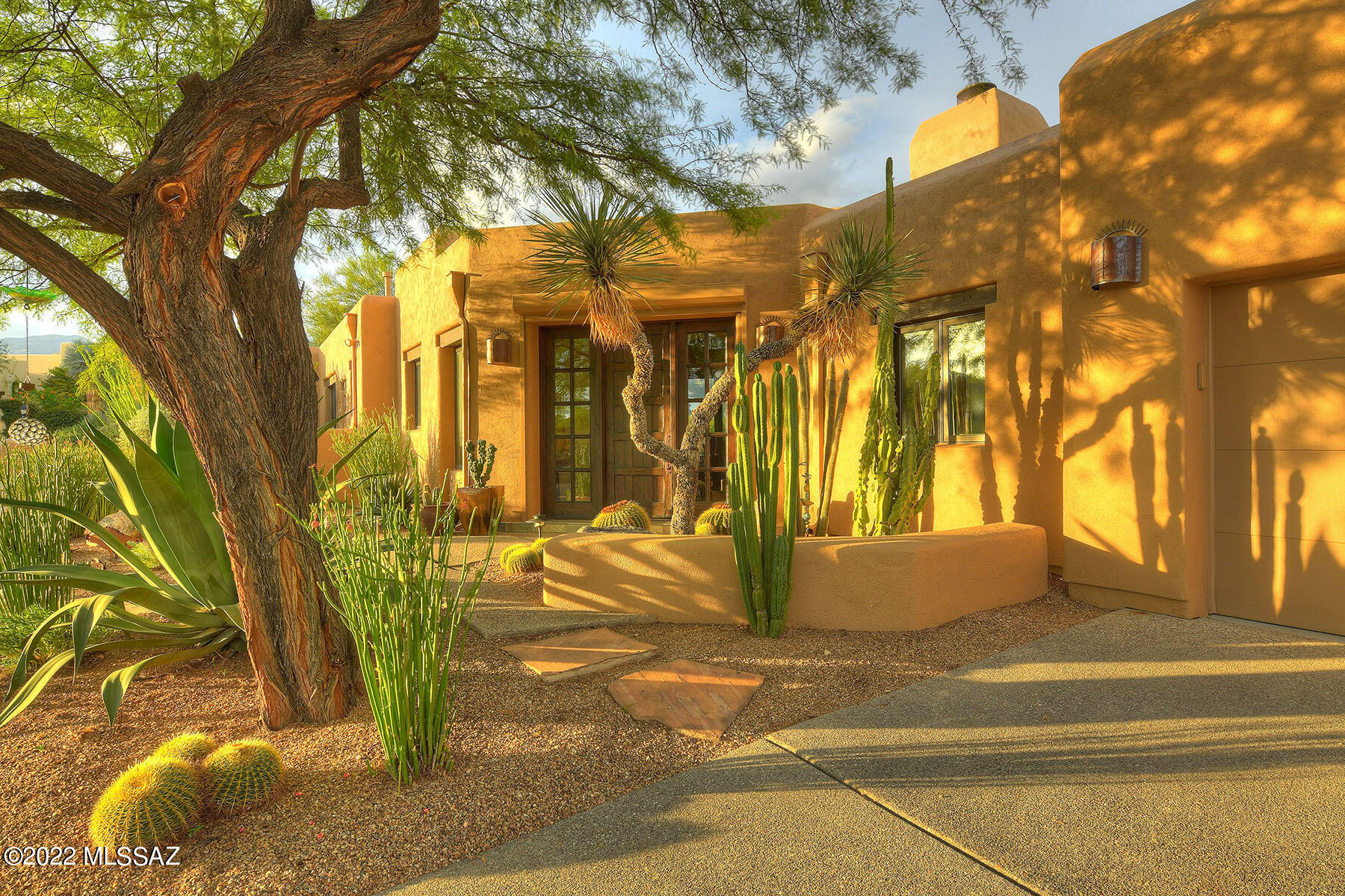 Stunning home in the world-renowned Canyon Ranch. Nestled on quiet cul-de-sac, this elevated lot has stunning views of Catalina & Rincon mountains from inside & out. All details have been considered in this impeccably maintained, desert-inspired home. Imagined by award winning interior designer Lori Carroll, every inch of space has been done to perfection. Entering through the solid wood territorial style front door your eyes are drawn to the light filled foyer & fabulous great room. The kitchen acts as a luxurious anchor for the home w/counter to ceiling glass tile backsplash, stone countertops & custom wood cabinetry w/integrated lighting. Thermador appliances are a mix of stainless & wood...
SEE MORE TAB Thermador appliances are clad in a mix of stainless & wood including a refrigerator, separate freezer, microwave, gas range, hood & dishwasher. The great room features exposed beams, high ceilings & in wall surround sound speakers. Dining area features backyard access & custom wall-mount, textured storage cabinet. Open living room is ideal for entertaining & features a stone-clad beehive fireplace, comprehensive lighting plan & desert-inspired color palette.  
Primary suite has Berber carpet, exposed beams & private outdoor access as well as separate office w/stone counters, built in desk, ample cabinetry & floating shelves. Primary bathroom includes thoughtful touches & natural materials. Extra-large double travertine tile vanities, sandblasted wood cabinets, travertine flooring & shower gives a spa-like experience at home. Personal stacked laundry facilities & large walk-in-closet w/custom built ins complete the suite while adding everyday functionality. 
There is an additional entrance to the pool area through the second primary suite with luxuriously appointed bath, built-in desk, custom cabinetry & stunning mountain views.  En-Suite bath features slate tile floors, natural light, separate water closet, stone vanity & glass enclosed walk in shower w/mosaic tile. Additional bedroom includes desert views, walk-in closet while the 3rd full bath includes large custom vanity, slate tile floors & contemporary walk-in shower.
Outside, the backyard resembles a 5-star resort. A sparkling pool w/custom tile surround & spectacular Catalina Mountain views invites you to relax. The covered outdoor area is ideal for entertaining w/beamed ceiling, fan, built-in heaters & extensive lighting plan. Fabulous outdoor kitchen features a professional grill, stainless refrigerator & stone countertops.  Easy-care xeriscape landscaping plan including mature trees & many species of cacti feeling simultaneously lush & inviting. 
The area near the garage features walk in pantry, coat closet, laundry room w/ built-ins, folding area & sink. 2.5 garage spaces, over height ceiling w/ storage & access to golf cart garage/workshop space.  
Canyon Ranch membership includes, athletic and exercise facilities, guarded gate, walking/jogging path, golf center, clay and standard tennis courts, world class spa, pickle ball, racquet ball, ropes challenge course, healthy fine dining as well as access to a wide variety wellness professionals.