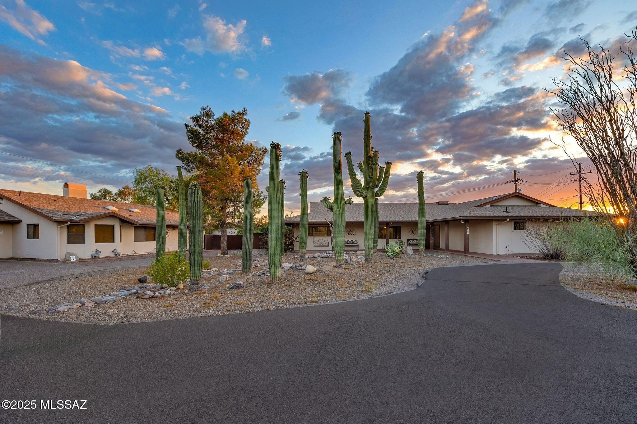 Exceptional property with stunning mountain views & mature saguaros. The main house offers 3 bedrooms 2.5 baths & a separate entrance to a studio or office with its own half bath. A detached large 1 bedroom guest house includes a full kitchen living space, laundry room & its own one car garage. The second unit can be used as guest quarters. The backyard is an entertainer's dream with a sparkling pool, hot tub and wet bar on the patio & a fire pit.  A sandy play area for kids and a trampoline. A rare desert retreat with room for everyone.