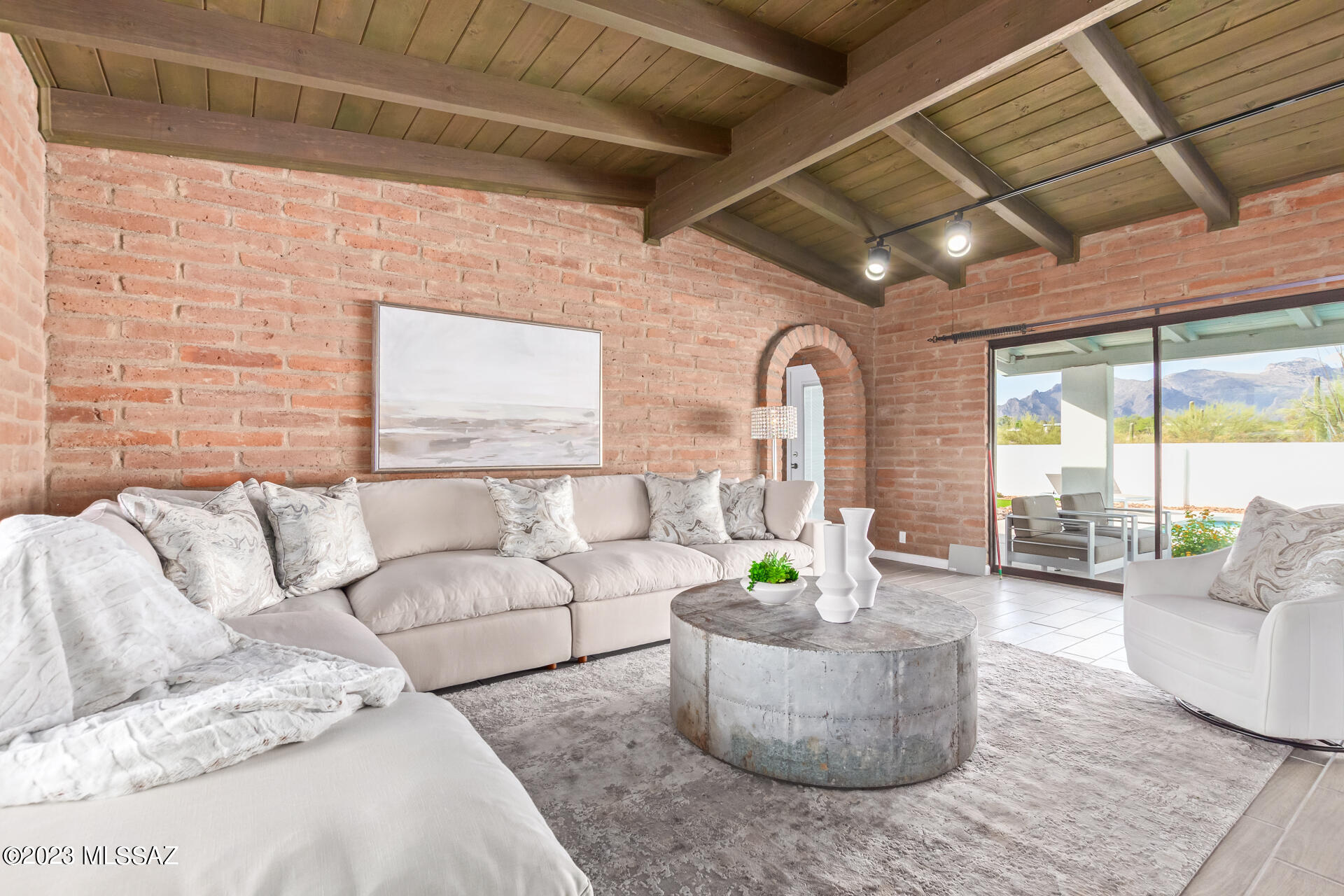 This stunning 5-bed 4-bath residence is on a sprawling elevated 1-acre lot is nestled against a majestic mountain backdrop. As you approach the circular driveway, the welcoming front porch w/ city views invites you inside. Fall in love with the open layout featuring vaulted ceilings, exposed beams, adobe accent walls, natural light, a cozy fireplace and captivating mountain views. The well-appointed kitchen comes with granite counters, skylights, recessed lighting, and SS appliances, that complement the overall aesthetic. The main bedroom boasts a large picture window that frames the Beautiful Catalina Mountains, backyard access, a walk-in closet, and a private bathroom w/ a rain shower. The guest house has a separate entry offering privacy for guests or potential rental opportunities. The beautifully landscaped backyard displays a covered patio, low-maintenance artificial turf, built in bbq, and sparkling pool - a refreshing retreat on warm days. The breathtaking sunset views create an idyllic setting for outdoor gatherings. The home has new HVAC units and water heater and is completely turn-key move-in ready. This home is what Tucson living is all about!