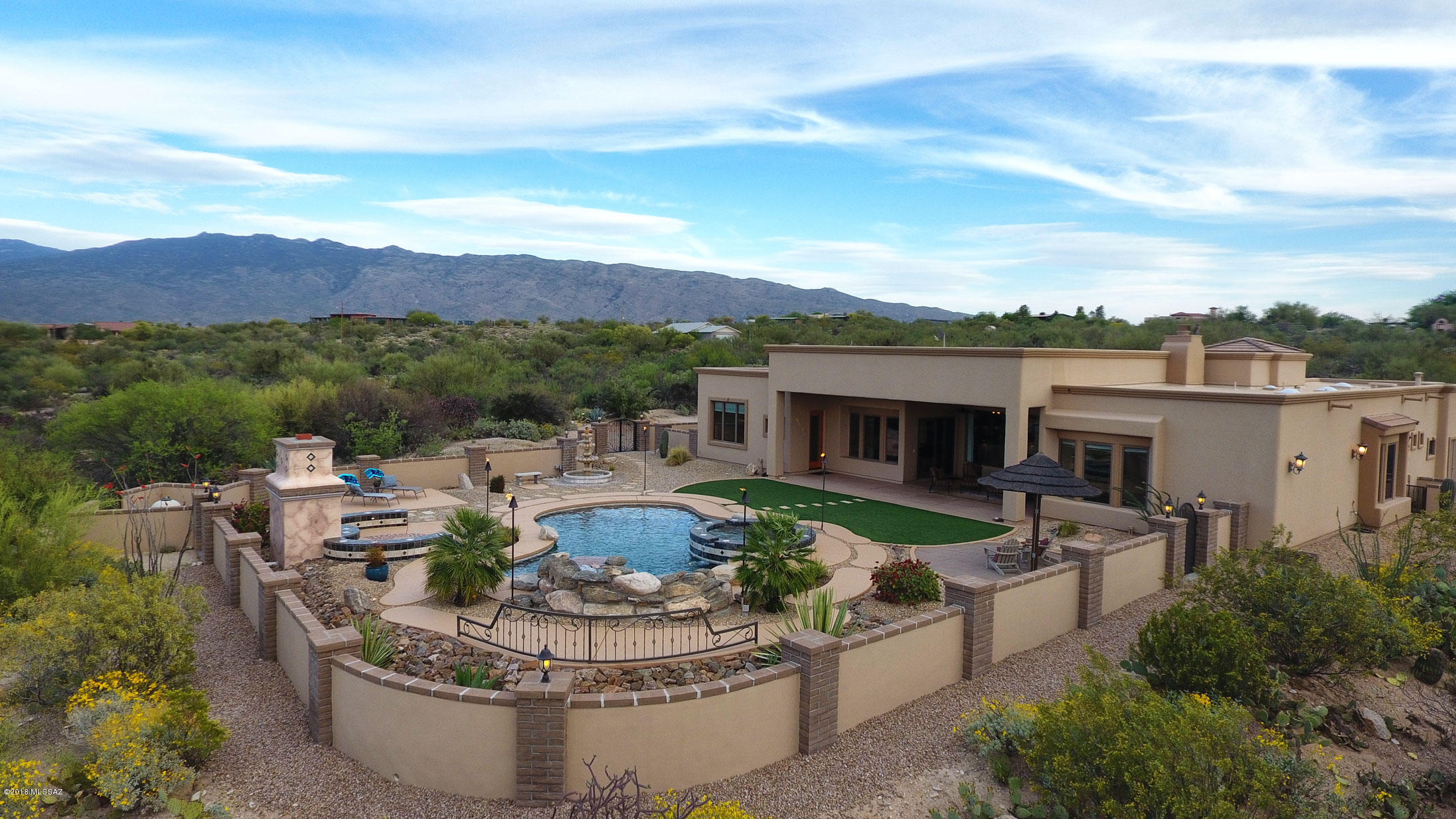 The builder of this 5 bedroom, 4.5 bathroom 3,703 sq ft custom home capitalized on the stunning panoramic mountain views.   The living room has unobstructed north facing full length windows with views of resort-like backyard with Catalina Mountain backdrop.   Enjoy outdoor living with a huge covered patio, hot tub, pool, fireplace, artificial grass, sandy beach area, tiki torches plumbed to home's propane tank, fountains, a putting green and views in every direction. Private gated driveway leads you to welcoming courtyard with fountain and great views through the house to the stunning backyard.  Kitchen is a chef's dream with all new Wolf, Sub-Zero & Kitchen Aid appliances in 2016. Don't miss the Virtual Tour on this listing. In the photos tab click Virtual Tour (U), then 3D Tour. High ceilings are accented by 8-ft alder doors and Andersen windows throughout.  400-Amp service panel, 3-car garage with epoxy floors and built-in vacuum.  Dolphin Premier Robotic In-Ground Pool Cleaner stored in garage and Solar Breeze Pool Skimmer do not convey.