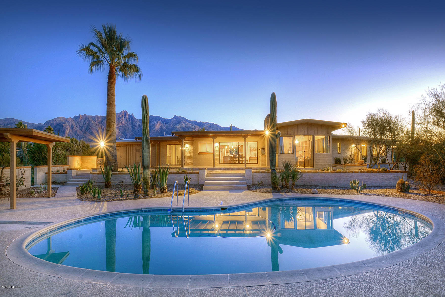 Stunningly remodeled mid-century, burnt adobe ranch-style home nestled in the heart of the ''Old Foothills'' on a private, 1.02 acre lot with Finger Rock, city and mountain views, 4 bedrooms plus bonus/game room and 3,899 sq. ft. split floor plan.  With an abundance of saguaros and native desert landscaping, walk into foyer to see living room with cozy beamed and planked ceilings and fireplace, family room with wet bar and disappearing 4 panel sliding door, brand new wood grained ceramic tile and carpeted floors throughout, remodeled kitchen with all new stainless steel appliances, quartz countertops throughout, all new windows and doors throughout.