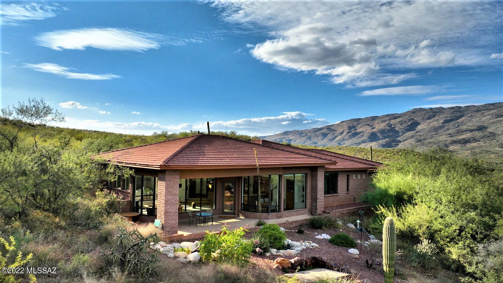 Come experience spectacular mountain views by day and star-studded night skies from this very special home nestled in X9 Ranch which is surrounded by National forest. The sky-hi ceilings, wide open flrpln & walls of windows bring the beauty of the mountain vistas & lush Sonoran Desert inside while you enjoy all the creature comforts this lovely low-maintenance home provides. Kitchen opens to the greatroom & offers plenty of cabinets & counter space, SS appl, island & bkfast bar. Spacious Primary w/ensuite bath w/dual sinks, curved walk-in shower & large closet. Den/study w/lots of built-ins. Located in a rich riparian habitat known for hiking, biking, birding & abundant wildlife. 2 new AC units, energy efficient TEP guaranteed, 3-car gar & tons of storage round out this fantastic property.