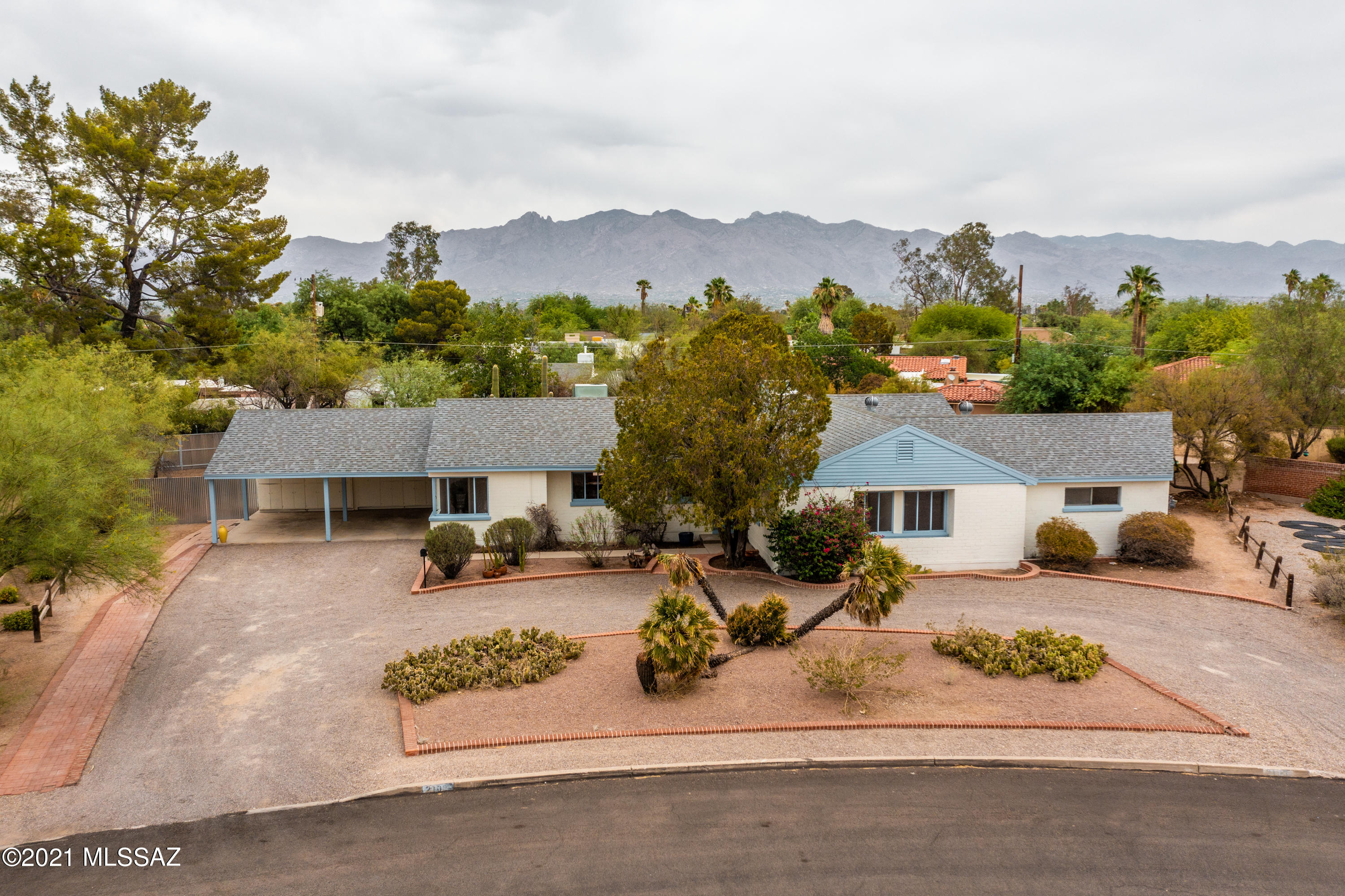 This beautiful home is set on a huge lot  and is within walking/biking distance to UMC Banner, UA and the Arizona Inn. The tremendous potential of this home coupled with its unique aesthetic lends itself to a variety of styles - from mid-century modern to desert ranch.  Multiple spaces offer amazing flexibility.  Features include two primary suites or guest quarters, a 5th ensuite bedroom that could also function as an in-home office, family/Arizona room with a wall of glass windows/doors opening onto the north facing yard, a sizeable pool in a separate yard, a large workshop with ''bike barn'', and your very own park across the street!  Freshly painted inside and out, sanded and restained scored concrete floors, newer roof (2013).  LOWERED PROPERTY TAXES DUE TO HISTORIC TAX STATUS.