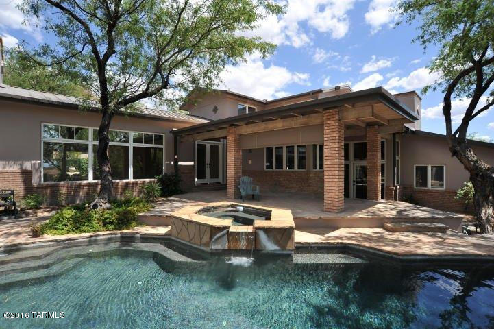 Outstanding, remodeled contemporary on the lake and golf course in prestigious, gated Ventana Canyon Estates. Designed by architect Bill Gansline, this 4 bedroom 2 3/4 bath home with metal roof features courtyard entry into living room with soaring cathedral ceiling, walls of windows and 24''x24'' travertine floors. Remodeled baths, new carpet, new knotty alder doors, gourmet kitchen with granite counters and designer appliances adjacent to cozy family room with fireplace and built-ins. Gracious master suite with his/hers closets and balcony overlooking the lake, golf course and city lights. Wonderful rear yard with lush vegetation, pool and spa and so much more. Garage has designated area for golf cart.