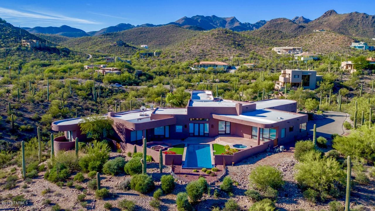 This meticulously maintained 4 bedroom, 5 bath, den, 3-car garage, hill-top beauty, designed & built by renowned architect John Campisano & tastefully decorated by award winning designer Lori Carroll, is situated on 2.2 acres to capture breathtaking city & mountain views from every room. This fully automated Smart Home is perfect for entertaining.  In addition to the master suite with large walk-in closet, the split floor plan offers 2 en suites for guests. Newly refinished hardwood floors add to the luxury of this custom built home. Stargaze by the negative edge pool, spa, or open fire pit with enclosed patio wall. Enjoy gorgeous sunsets from under a large portico in the walled-in courtyard. House is surrounded by saguaros in a quiet & friendly neighborhood you’ll be glad to call home!