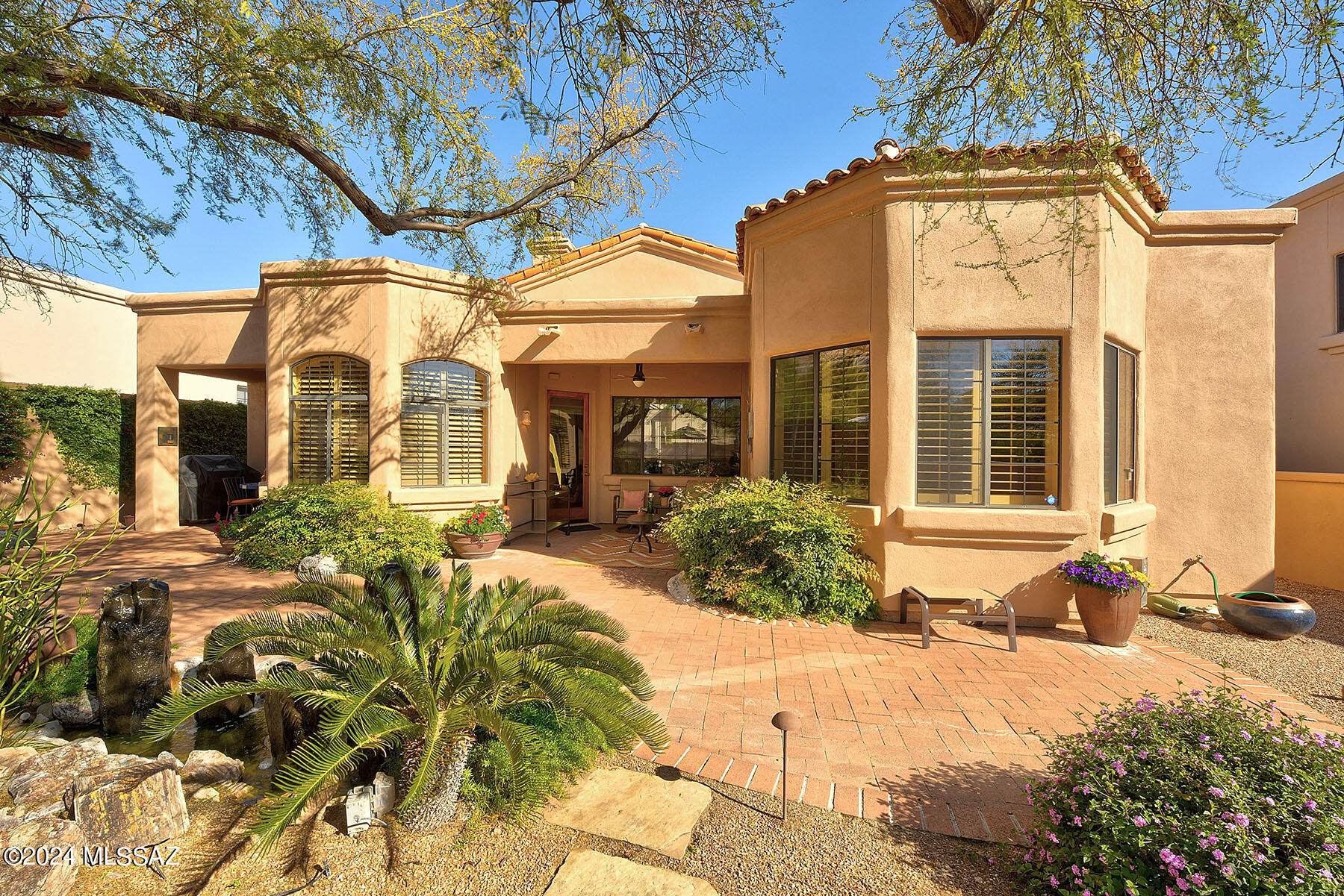 Come experience this 3 bedroom, 2&1/2 bath, 2162 square foot home in desirable La Paloma. Private guard gated community with manicured front yards & beautiful contemporary architecture typify this fantastic neighborhood. 
Through covered entry past impressive solid wood door the home opens into a light filled great room with clearstory windows & high ceilings. Great room boasts niches for displaying your artwork while the cozy fireplace and acts as a prelude to the dining area. Dining room, with its charming bay windows overlooking the lush backyard, sets the stage for unforgettable meals. And let's not forget the heart of the home - the kitchen. Boasting a thoughtfully designed two-tier island, it's a perfect spot for meal prep & enjoying your morning coffee. See MORE tab Plus, the breakfast nook with sliding door access to the backyard makes al fresco dining a breeze. 
Convenience meets functionality in the separate laundry room, complete with a prep sink and ample storage space. The luxurious primary bedroom, featuring bay windows for abundant natural light & sliding glass doors that lead to the covered patio - the ideal spot for relaxation and tranquility. The ensuite bathroom is a true oasis, with a large walk-in closet, dual vanity, jetted tub, separate shower, & private toilet room. The second bedroom seamlessly transforms from a spacious library or sitting room into a cozy guest retreat, thanks to its Murphy bed & built in bookshelves. For those who work from home, bedroom #3 offers a well-conceived T-shaped desk, making it a highly functional space. 
Step outside to your private backyard sanctuary, where a covered paver patio, soothing fountain, fire pit can all be enjoyed in the shaded flagstone seating area await. Get ready to be enchanted by the profusion of spring flowers that will take your breath away. With its impeccable design, luxurious amenities, and prime location, this home is truly a rare find.