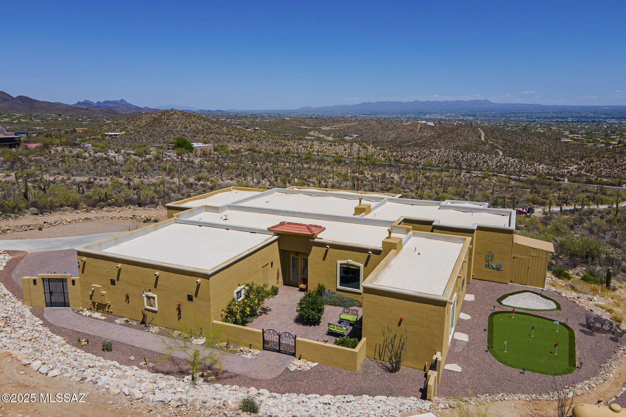 Luxury custom-built home completed in 2023, perched atop a hill in West Tucson with commanding views of Downtown Tucson, A Mountain, and the Rincon & Catalina Mountains. This 4-bed, 5-bath, 4,925 sq ft home is a perfect blend of modern elegance and off-grid living with a dedicated generator and propane tank. The open-concept design features expansive living spaces, floor-to-ceiling windows, and high-end finishes throughout. Enjoy seamless open space indoor-outdoor flow, spa-inspired baths, a gourmet kitchen with stainless steel appliances, and multiple covered patios. Practice your golf game with a putting green overlooking the city. A rare offering of privacy, sophistication, and sustainability just minutes from city conveniences.