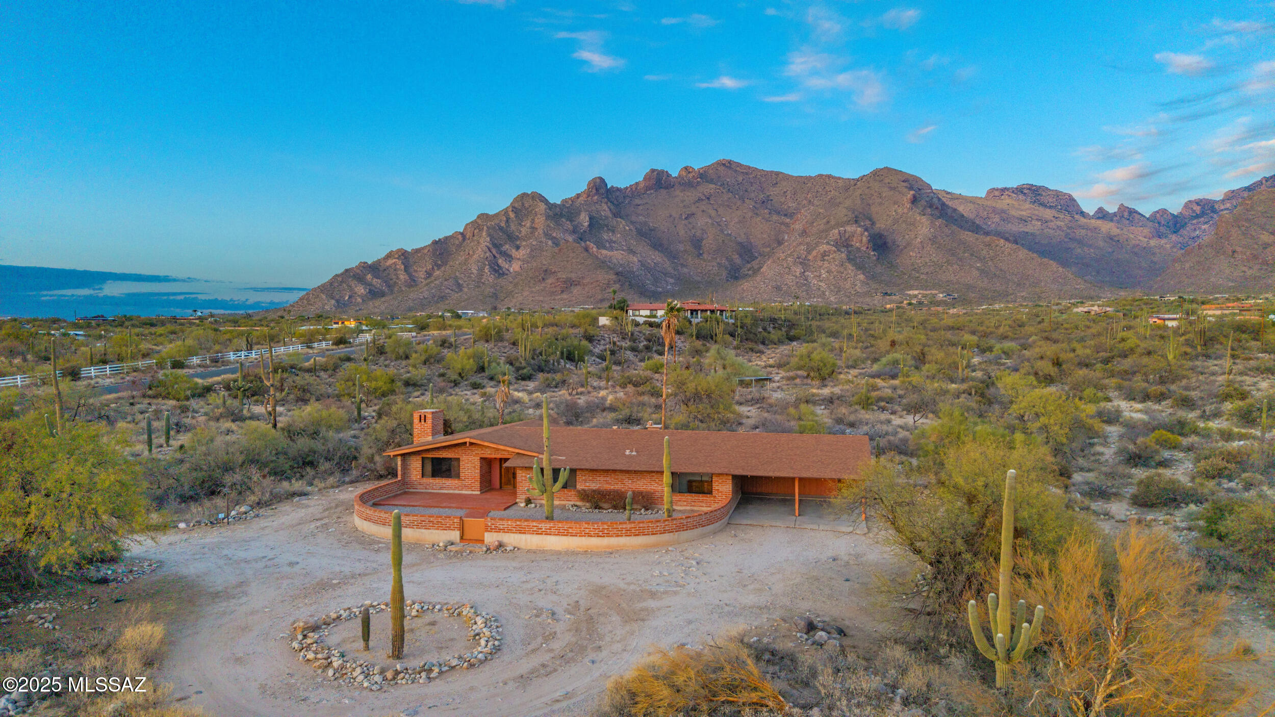 Uncover the allure and genuine essence of this original Tom Gist-built home, a rare jewel that showcases master craftsmanship and distinctive desert design. Renowned for their elongated floor plans, expansive view-oriented window walls, burnt adobe construction, and rich wood accents, Gist homes are truly exceptional. This timeless 3-bedroom, 2-bath residence features impressive high-beam ceilings, rustic brick paver flooring, and a cozy wood-burning brick fireplace in the great room, beautifully complemented by exquisite wood cabinetry and built-ins. Savor breathtaking city and mountain views at sunrise and sunset from inviting patios that capture the scenery from virtually every angle. Set on 7.59 acres, this horse-friendly property is ideally situated near the University of Arizona, downtown Tucson, and Pima Canyon. Don't miss this unique opportunity to own a piece of Tucson foothills magic and history!