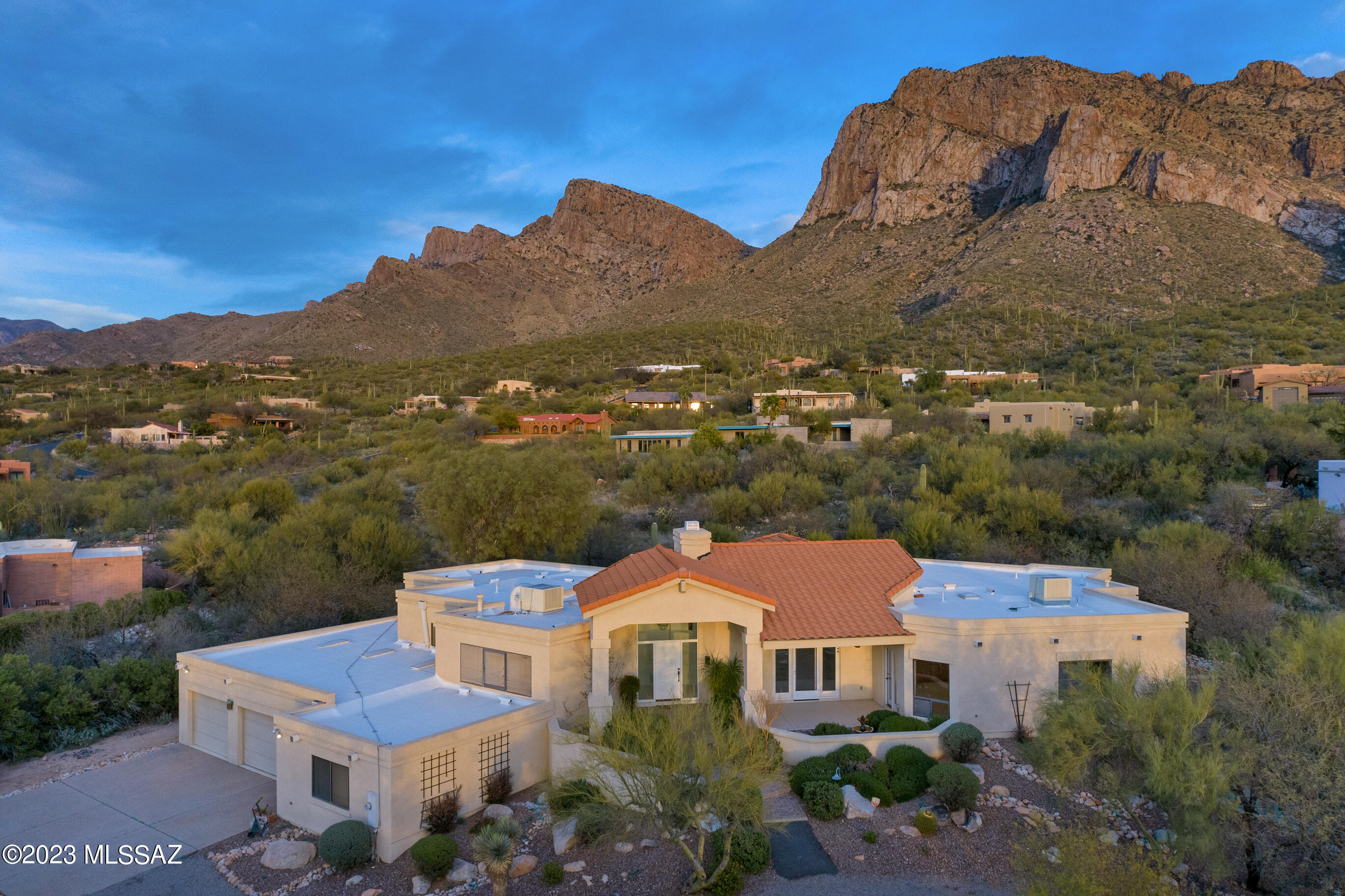 Incredible location nestled at the base of Pusch Ridge with unfathomable views of the most glorious mountain in Tucson. Soaring wood beamed vaulted ceilings & a wall of windows framing this fabulous mountain will captivate you instantly. PLUS.. From the front of this contemporary custom home you have even more amazing VIEWS to include the most majestic sunset views. This fabulous 3 bedroom, 3 bathroom home with a split floorplan is move-in ready, freshly painted with new carpet in the living room, bedrooms, etc. Gourmet kitchen with SubZero fridge, JennAire cooktop in the island all with an inspiring mountain view! Gorgeous pool & raised spa with waterfall  against the backdrop of..YES..Pusch Ridge. So close you can touch it! A stones throw from the Coronado National Forest.