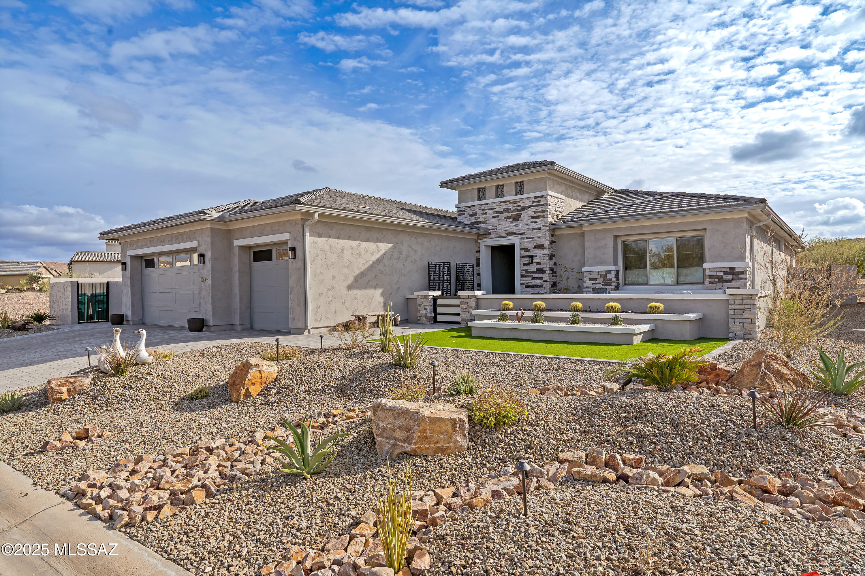 Wake up to breathtaking sunrises from your back patio and unwind with stunning sunsets from your front courtyard. This impeccably designed Bacara model offers the perfect blend of luxury and functionality, ideal for both intimate gatherings and grand entertaining. Step into the expansive great room, complete with a stylish bar, seamlessly flowing into the chef's kitchen—featuring high-end appliances, a spacious island, and a dedicated dining area. The stackable sliding glass doors open to the rear patio, creating a seamless indoor-outdoor experience. With the roller shades down and the fireplace aglow, this space transforms into a cozy retreat overlooking a beautifully landscaped backyard, an open wash, and scenic walking trails. With three full bedrooms and a spacious den, there's plenty of room for guests and activities. The split-bedroom layout ensures privacy, making it an ideal retreat for you and your visitors. The oversized three-car garage provides ample space for vehicles, golf carts, and hobbies. Loaded with premium upgrades, this exceptional home won't be on the market for long!