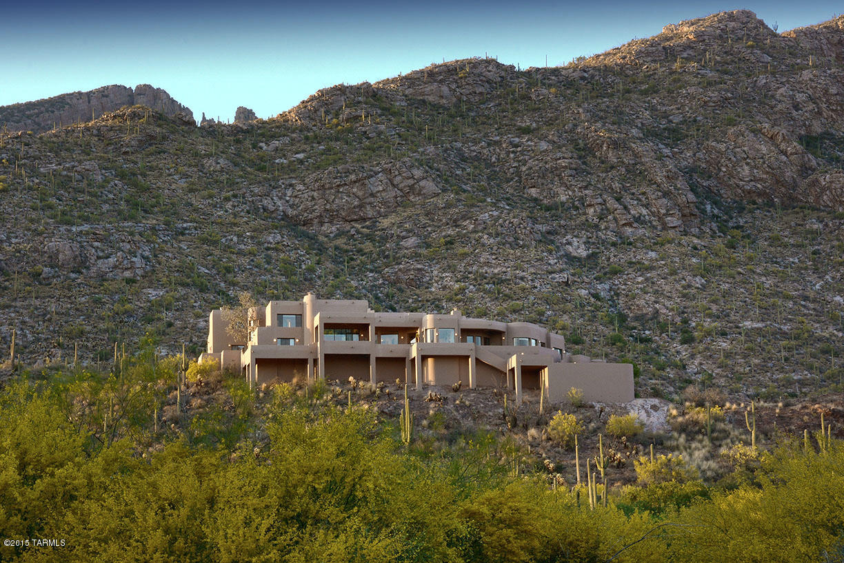 Stunning contemporary high on a ridge in the Catalina Foothills on 2.68 dividable acres with Finger Rock as the backdrop. Designed by Gene Goldstein and built by Jerry Albert, this 6388 sqft, 5 bedroom all masonry stucco home has electronic gated entry, sweeping, unobstructed  360 degree city and mountain views and great room with 20' soaring beamed ceilings and walls of windows, light and beehive fireplace. Gourmet kitchen with granite counters, gracious master with spa tub, loft/library, exercise room and workshop/studio, ample room for hobbyists and many guests. Saltillo tile and oak hardwood floors, art walls, patios, walkways, negative edge pool, spa and so much more. If you are looking for views, privacy, quality construction and space, don't miss this masterpiece.