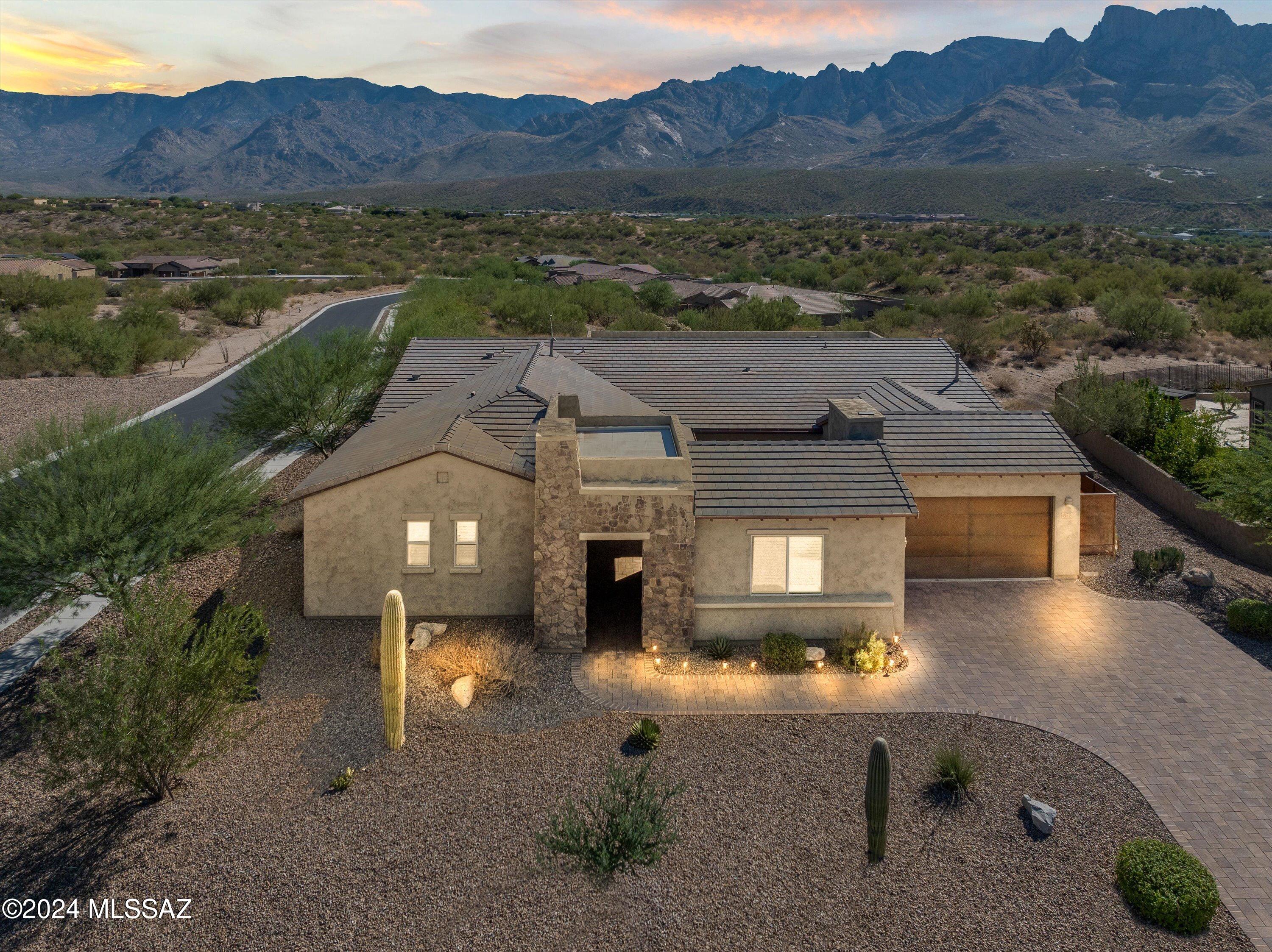 Experience exquisite unobstructed panoramic views of the Catalina Mountains in this stunning four-bedroom, four-bathroom home, complete with a separate office and bonus room, situated in the gated community of Sanctuary at Silverhawke.
This residence sits on .46 of an acre and features a spacious floor plan, highlighted by a beautiful kitchen equipped with high-end Kitchen Aid appliances, elegant granite countertops, and a walk-in pantry that is truly an organizer's dream. The thoughtfully designed split floor plan includes a primary suite, a junior suite, and two other bedrooms that are separated by shared space to enhance privacy. Wake up to breathtaking mountain views from the primary suite, where the spa-like bath awaits, showcasing an oversized walk-in shower, two separate vanities, and dual closets designed by California Closets.

Additional highlights include built-in surround sound integrated into the ceilings and walls, multi slide patio door, three car garage, custom California Closet cabinetry in the garage, tailored lighting throughout every room, and stylish window coverings.

The backyard is a true oasis, offering expansive views of the Catalina Mountains. Enjoy outdoor gatherings on the extended back patio, which features professional landscaping, a built-in BBQ, custom wrought iron fencing, a gas fire pit, and decorative accent lighting.

Don't miss this remarkable property that seamlessly combines luxury and comfort, making it the perfect haven living and entertaining!

Owner/Agent