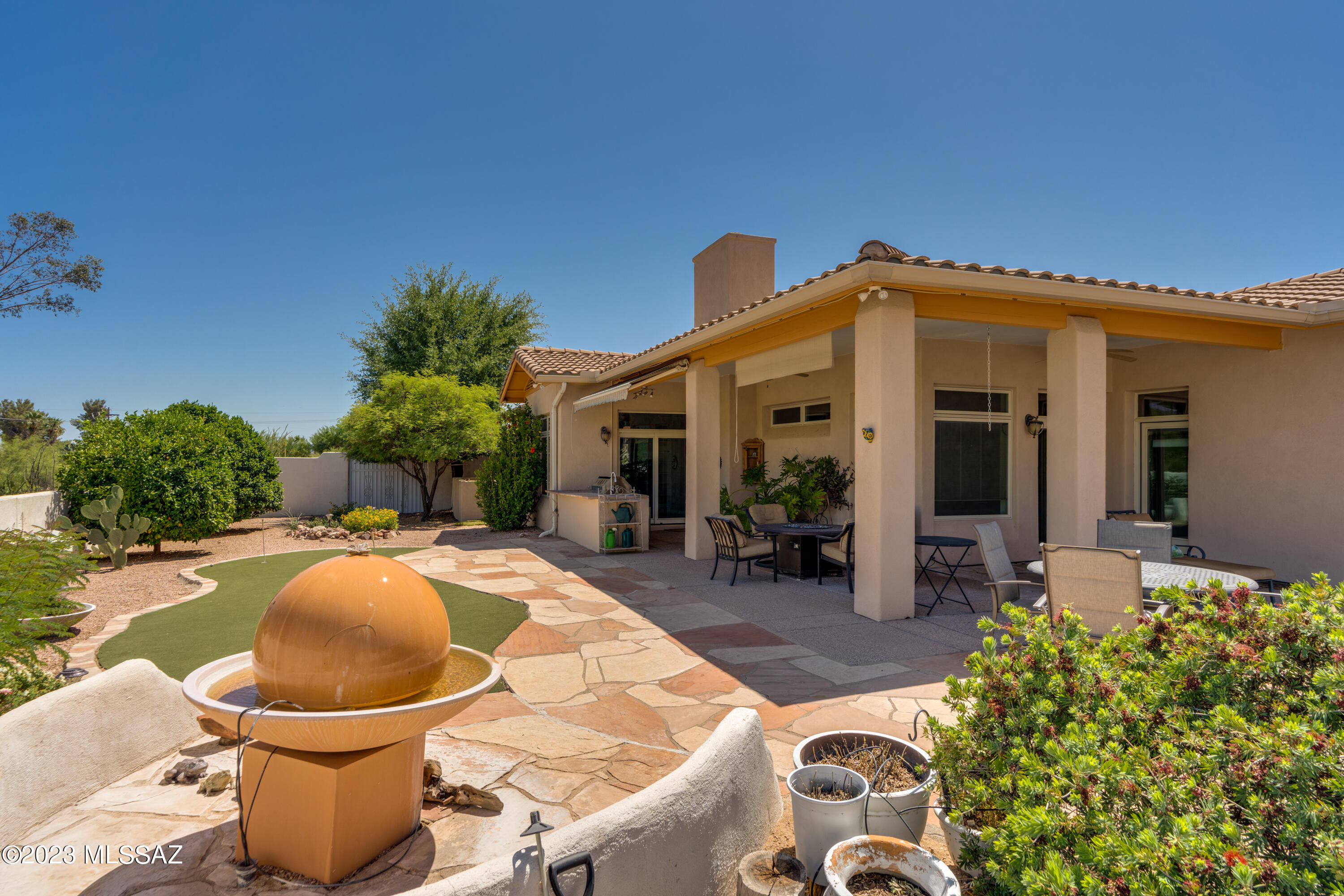 Amazing corner lot in guard gated Omni Tucson National Resort.  Three spacious bedrooms each with their own bath. Plenty of space for overnight guests or a home office.  Open kitchen with stainless steel appliances, pull outs in all lower cabinets and plenty of countertop space.
Granite countertops and large center island. This home has a great flow into dining and great room area. Oversized great room with gas fireplace, bar area with sink, or great coffee bar space. Light and bright den/dining with large slider to amazing resort style backyard that includes a putt-putt golf area and outdoor kitchen, lush green, flowering landscape. Electric shade awnings. Expansive views are sure to impress!  Head to the club in your own golf cart included with purchase.