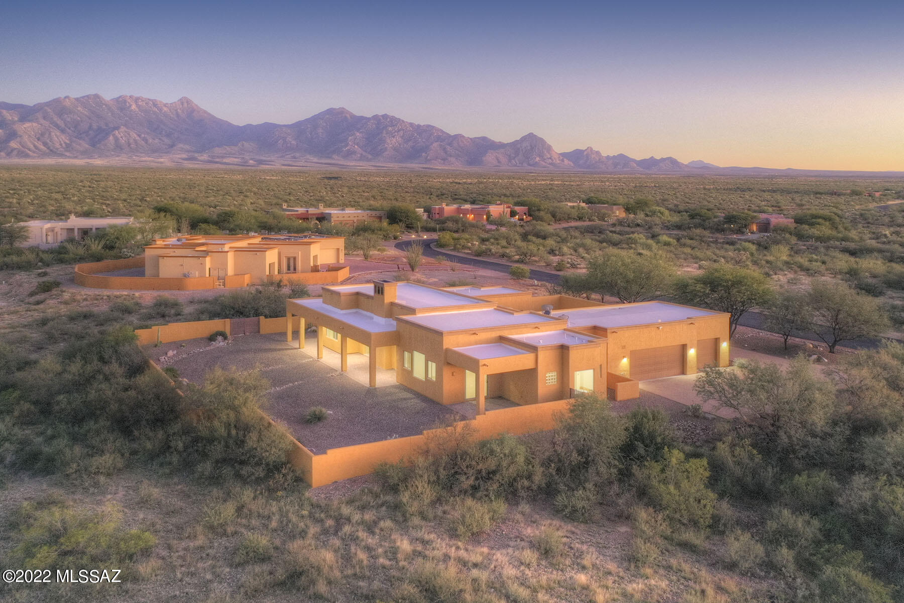 Inspired by Arizona's unique landscape, culture and climate, this gorgeous home in Madera
Shadows Estates is the desert sanctuary you have been dreaming of! Set against the backdrop
of both the Catalina and the Santa Rita Mountains, clean, crisp architectural lines and a
magnificent front courtyard give this home a sense of grandness without being ostentatious.
3000 sq ft of interior space creates plenty of options to gather with family and friends, and the
2.5 acres ensconcing the home provides extensive privacy and space for your outdoor living lifestyle.  Upon entering, the great room is impressive with gleaming travertine tiles flowing throughout and oversized windows framing the mountain views!  A glowing fireplace with floor to ceiling stamped concrete mantel commands attention. The stunning kitchen stands ready for entertaining with luxurious granite counters, custom wood cabinetry and a huge center island, all surrounded by mountain views.  Your primary suite has access to your private patio, a spa-like bath and more amazing views to wake up to.  Two additional bedrooms accommodate winter guests or his and hers private offices.  Whether your lifestyle is based on family, entertaining, or both, this elegantly designed yet traditional home is meant for a passionate and discriminating owner who is ready to embrace a modern desert lifestyle.