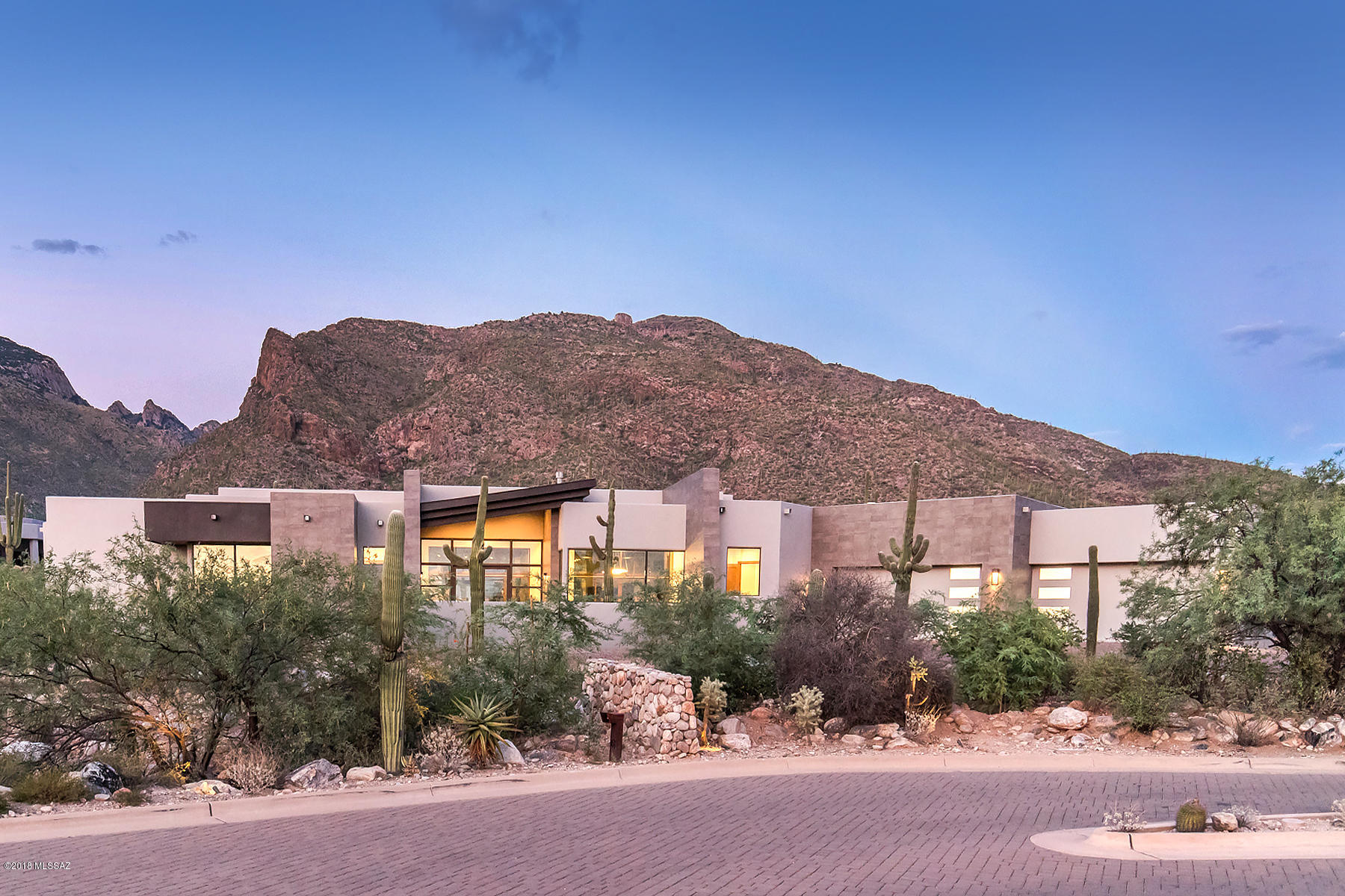 This 2018 spectacular, contemporary home, features interiors by nationally renowned designer Lori Carroll & Assoc. Located in prestigious Pima Canyon Est., this home showcases sleek contemporary lines that define living spaces with warmth, charm, and ambiance.  Gourmet kitchen boasts natural light, with a mix of natural materials & professionally inspired appliances.  Distinctive materials include: porcelain flooring that mimics the look of time worn leather; unique, wedge shaped subway tile at wet bar, 3-dimensional ceramic wall tile that turns the PR and MB into amazing landscapes.  Innovative linear cove lighting, w/LED technology, accents the high ceilings. Voluminous living areas create unmatched indoor/outdoor entertainment opportunities.
