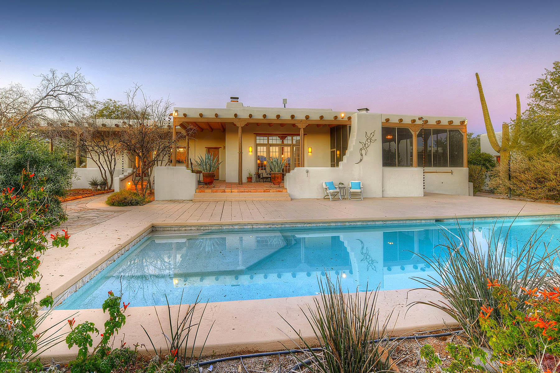 Authentic mud adobe Tucson Hacienda plus 2br/2ba Guest House on 3.3 acres!  Gracious private retreat nestled in lush Sonoran desert with saguaros, native cacti, fruit trees, majestic mountain views and angelic sunsets! Enter through courtyard to great room with soaring  herring bone ribbed & viga beamed ceilings, windows that frame the Catalina Mountains, Venetian plastered walls and corner fireplace.  16'' thick passive solar adobe walls maximize a comfortable lifestyle.  Remodeled chef's kitchen features hammered tin ceiling, quartzite counters, cherry cabinets and SS appliances. Enjoy meals in kitchen, breakfast bar, dining area or huge screened patio, while taking in the incredible views. Master suite invites relaxation with cozy beehive fireplace, jetted tub, huge shower & sitting area. Year round outdoor living under 2600+sqft of wrap-around covered patio with fireplace, banco seating and new solar heated pebble-tec pool.  Guests will enjoy the spacious 2BR/2/BA Guest House complete with living area, kitchenette, washer/dryer and screened in porch. 3 car garage with cooled workshop, carport and circular drive offers plenty of space for parking.  Private gated estate at end of road.  Convenient to Saguaro National Forest for great hiking and horseback riding yet only a short drive to UofA, downtown, restaurants and shopping.