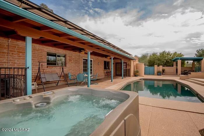 For the Ecology Connoisseur This burnt adobe/stucco home is centrally located in the lower portion of the Foothills adjacent to  amenities. 4 BD/2BA with attached 1BD/1BA in law on almost an acre. Rainwater catchment in place and solar panels on the roof.  The Tesla Solar lease provides electricity for around $25 a month. Updated kitchen w/hickory cabinets,gas cooktop, tile and bamboo flooring, fireplace, sparkling pool & spa,detached 1277 sq ft workshop (space for 6 cars) heated/evap cooled was used for woodshop, compressor included. Three 750 gallon water harvesting tanks on the property. Loads of storage for your toys. Freshly coated roof by Tim's Roofing