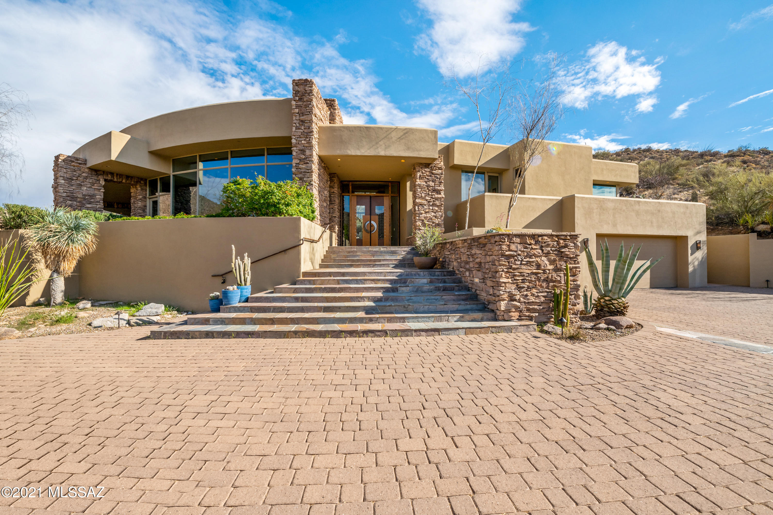 Custom architectural design by Kevin B Howard in the popular guard gated community of Canyon Pass in Dove Mountain. This exquisite property sits on an elevated and expanded lot with 4.45 acres of visual beauty. Floor to ceiling windows to capture full views of the Tortolita mountains and the Gallery North course fairways (#4 & #5). This home has been pre-inspected and is ready to go! Built of solid masonry construction, natural stone throughout, tri-level, grand entry, 6,239 total square feet with four bedrooms, den/media room, 4 1/2 baths, formal living and dining areas, family room, breakfast nook, wet bar and three fireplaces. The luxury owners retreat is spacious with fireplace, private outdoor hot tub, spa like bath, split dual closets with a second washer/dryer hookup (stackable), large walk in shower and jetted tub with views of the calming waterfall in the rear courtyard.  The two guest rooms in the main house are across from the library/sitting area and each have their own private bath and a shared balcony with golf course views.  Your guests/teenager/in-laws will enjoy the separate guest casita with kitchenette and access to the rear courtyard. The lower level 2 car garage has a separate street entrance, storage room and also includes an expansive wine cellar! There are multiple outdoor areas for you to enjoy year-round including a negative edge pool, outdoor kitchen and dining space, rear courtyard with lush vegetation, privacy and large natural rock waterfall, huge upper patio deck that is perfect for entertaining and offers breathtaking views of multiple mountain ranges and city lights!  Close to multiple golf courses, Ritz Carlton, new STEM school, easy access to I-10, shopping and dining.
