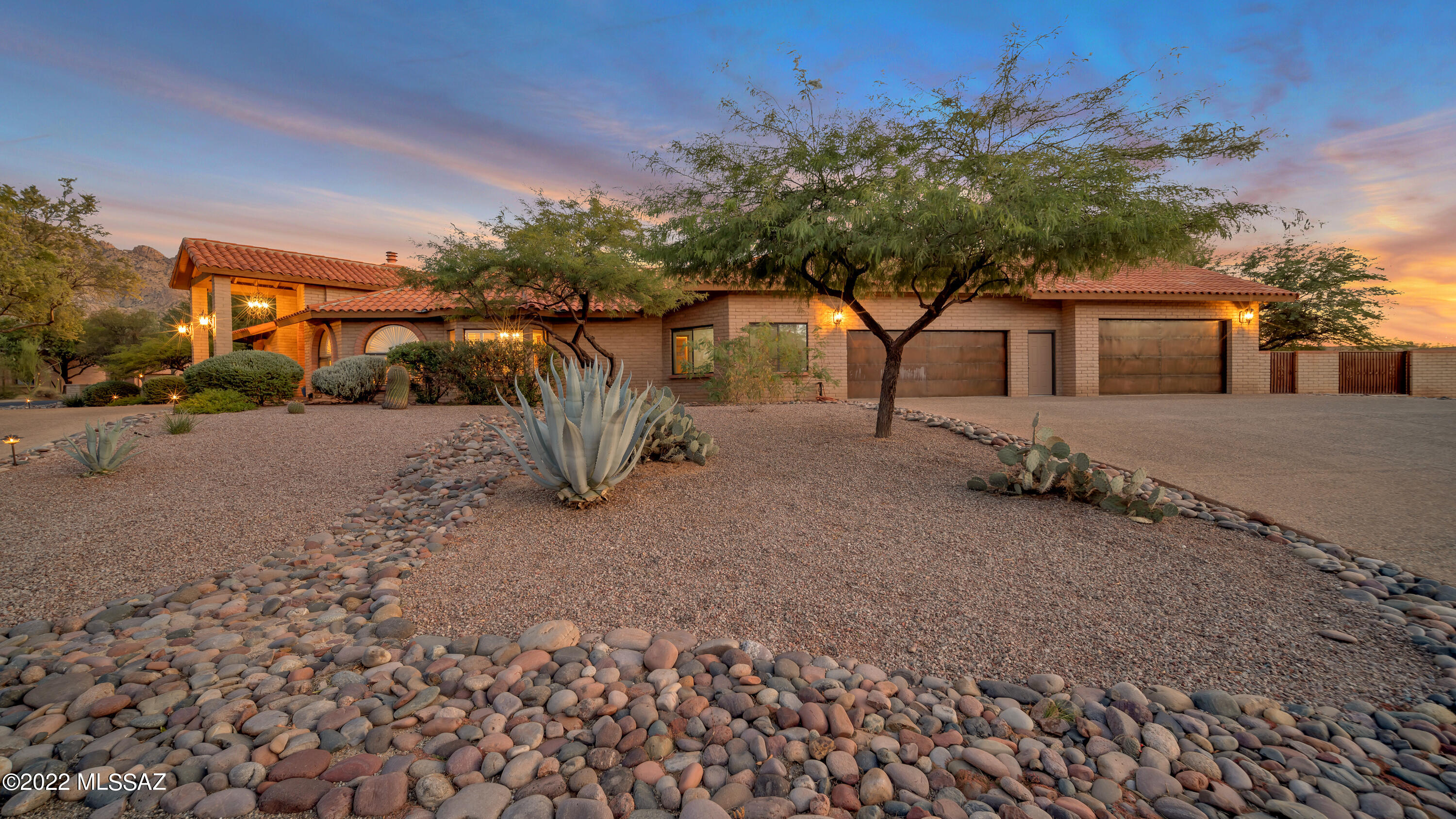 Located in Beautiful Oro Valley Estates on an Elevated lot with mountain views from the spacious back yard with a large sport court, pool & spa with shady ramada, multiple fruit trees and patios. Enjoy cool winter evenings by the beehive fireplace with seating wall. Your guests will enter through the grand wood, glass and wrought iron double doors. This updated SW Contemporary home has a large kitchen with a spacious island, granite countertops and new stove top and beverage refrigerator. Travertine tile, 4 car AC heated/cooled garage with epoxy flooring and finished attic. Hot water heaters have recirculation pumps for immediate hot water.  Corner Lot.